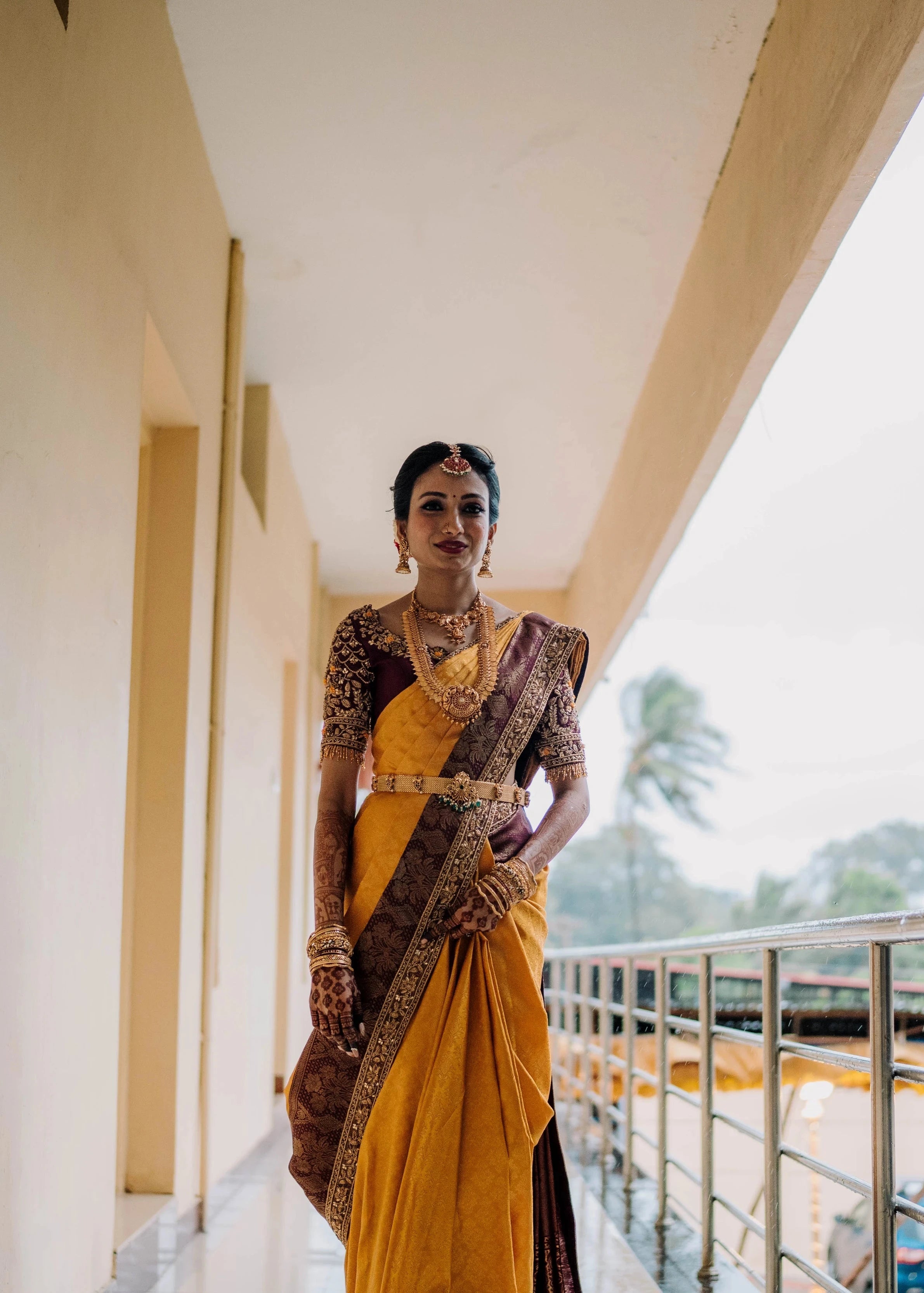 Bride Anusha K smiling during photoshoot in a wine red concept raw silk blouse, veil and saree border, handcrafted with zardosi, beads, resham, crystals, sequins etc by Archana Karthick.
