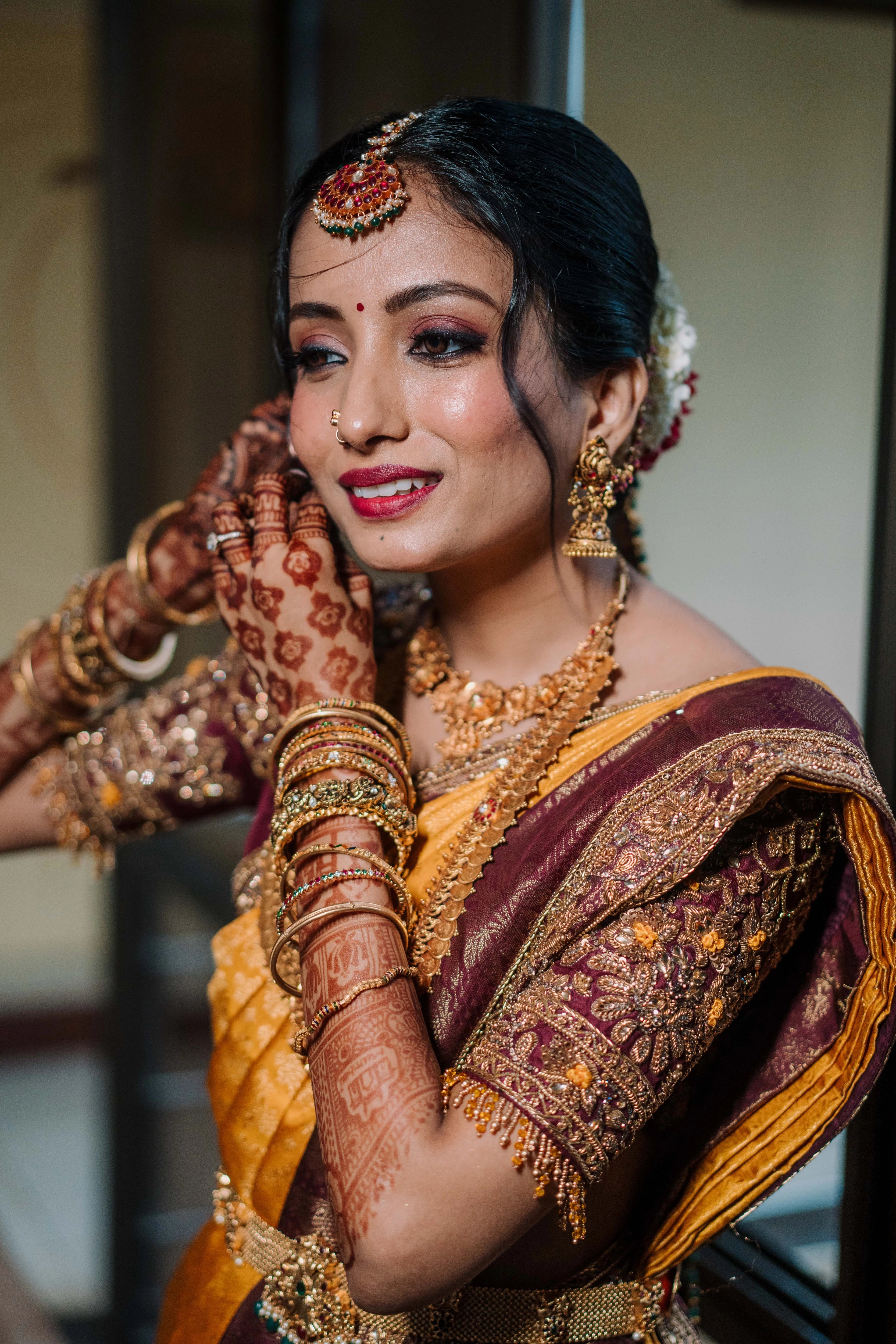 Bride Anusha K wearing jewelry in a wine red concept raw silk blouse, veil and saree border, handcrafted with zardosi, beads, resham, crystals, sequins etc by Archana Karthick.