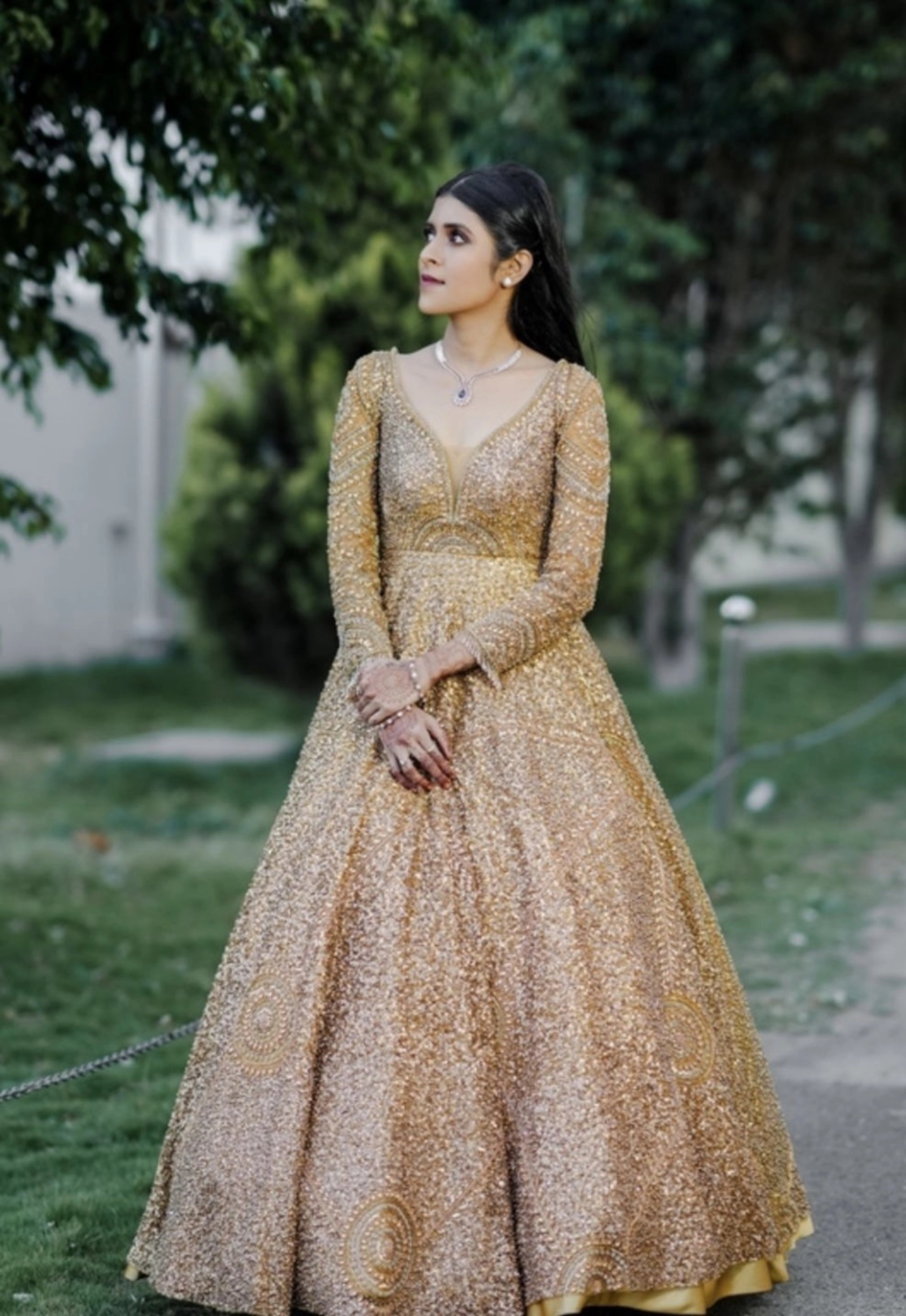 Bride Aswathi in a tulle gold gown handcrafted by team Archana Karthick.