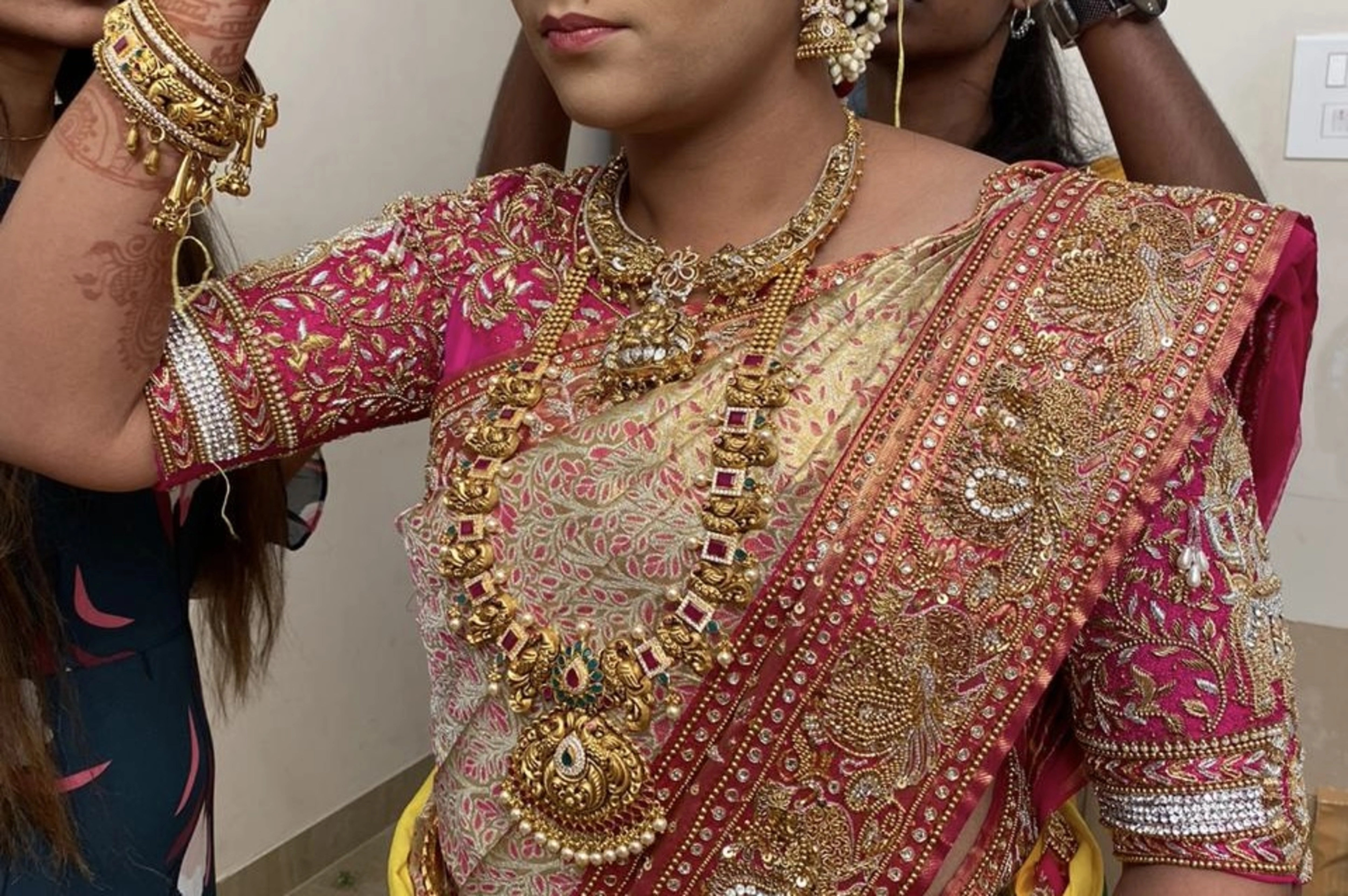 Bride Barani Lekha during makeup in an intricately handcrafted pink silk blouse and saree border with zardozi, beads, stones, sequins and hangings by team Archana Karthick.
