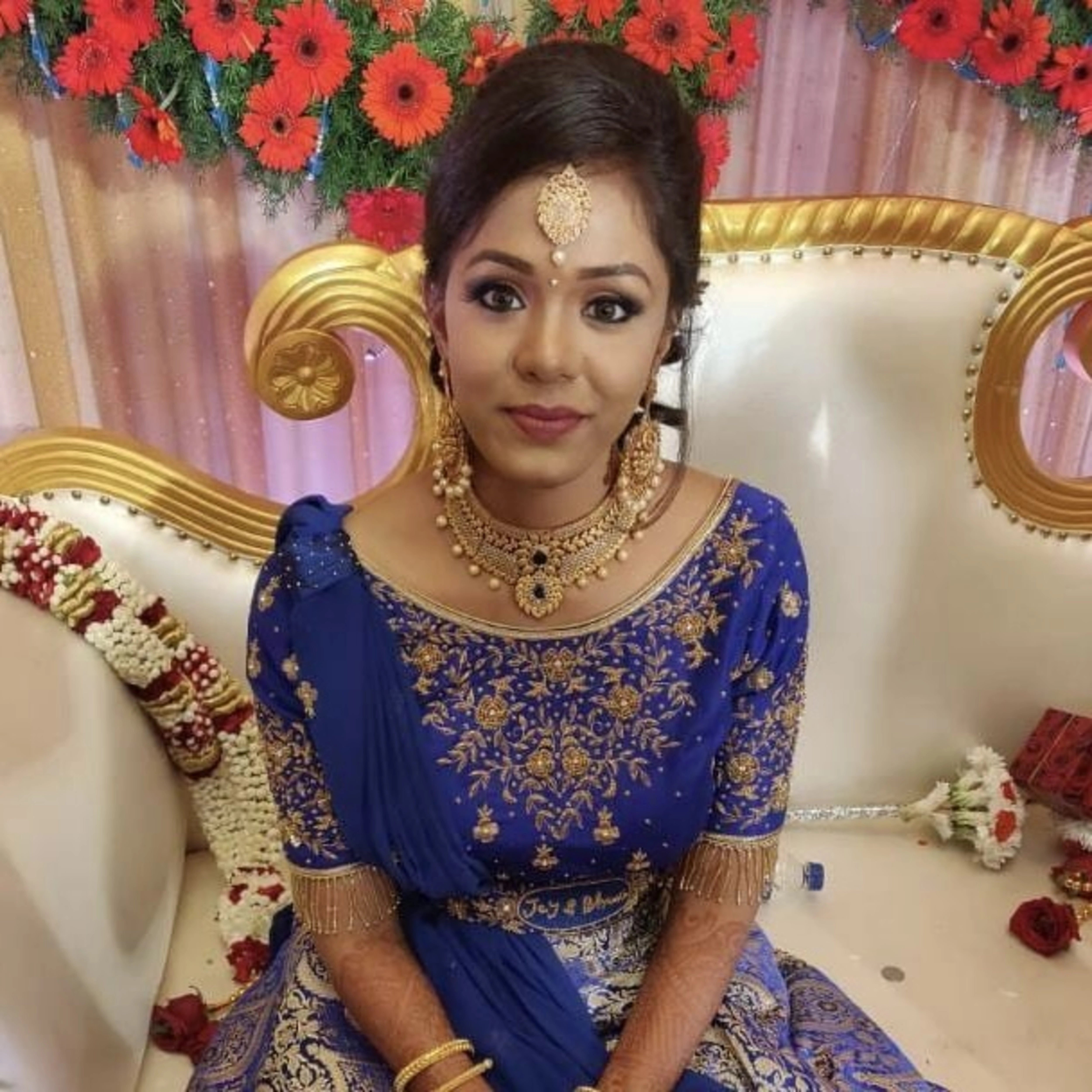 Bride Bhuvana from Chennai smiling in a blue and silver brocade with belt, intricately handcrafted with beads and zardozi by team Archana Karthick.