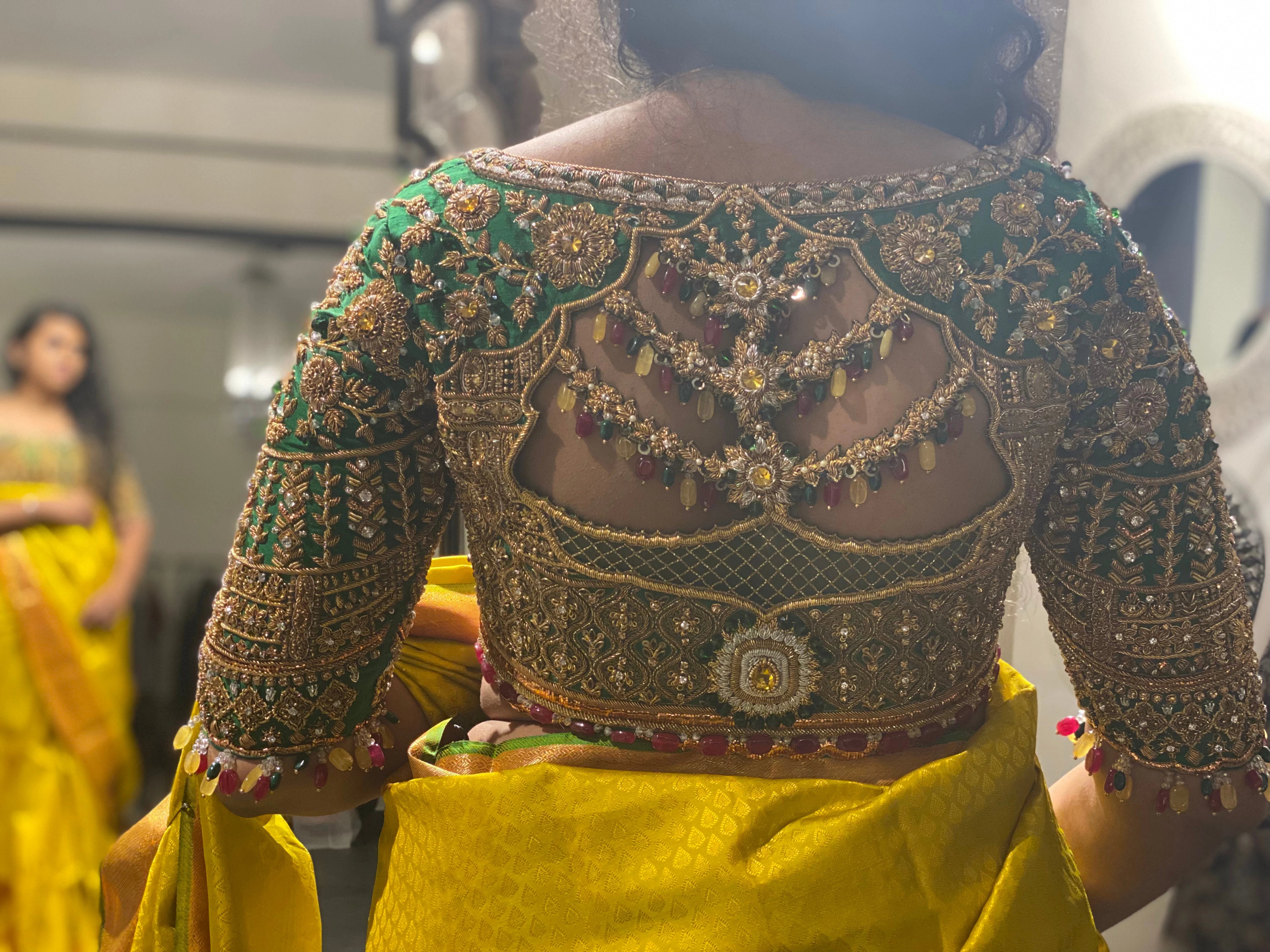 Bride Cris during fittings in a bottle green silk blouse handcrafted by team Archana Karthick.