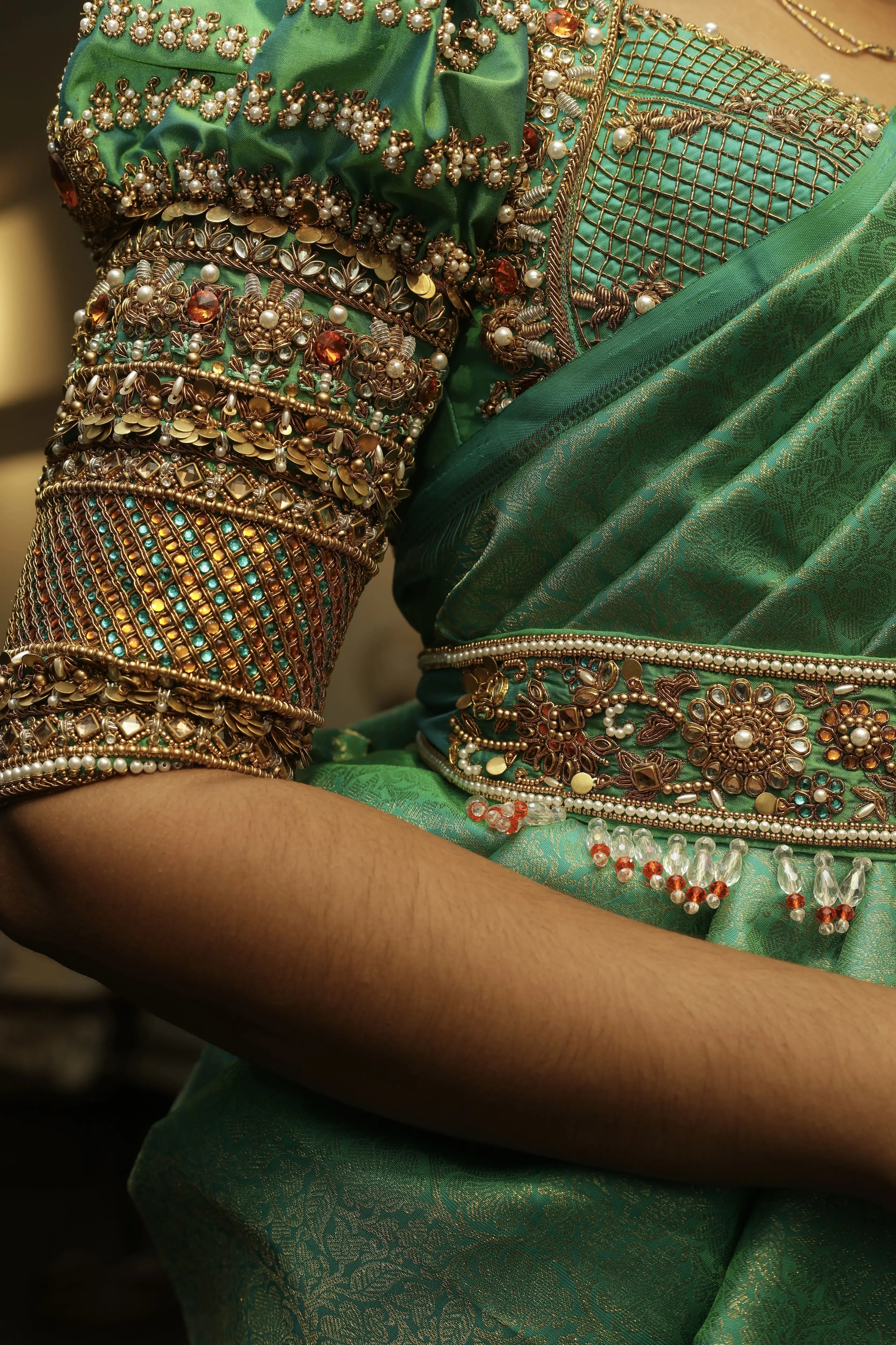 Bride Cris posing in a sea green puff sleeved silk blouse & belt, tulle veil, handcrafted with appliques, beads, kundan, stones, crystals, etc by team Archana Karthick