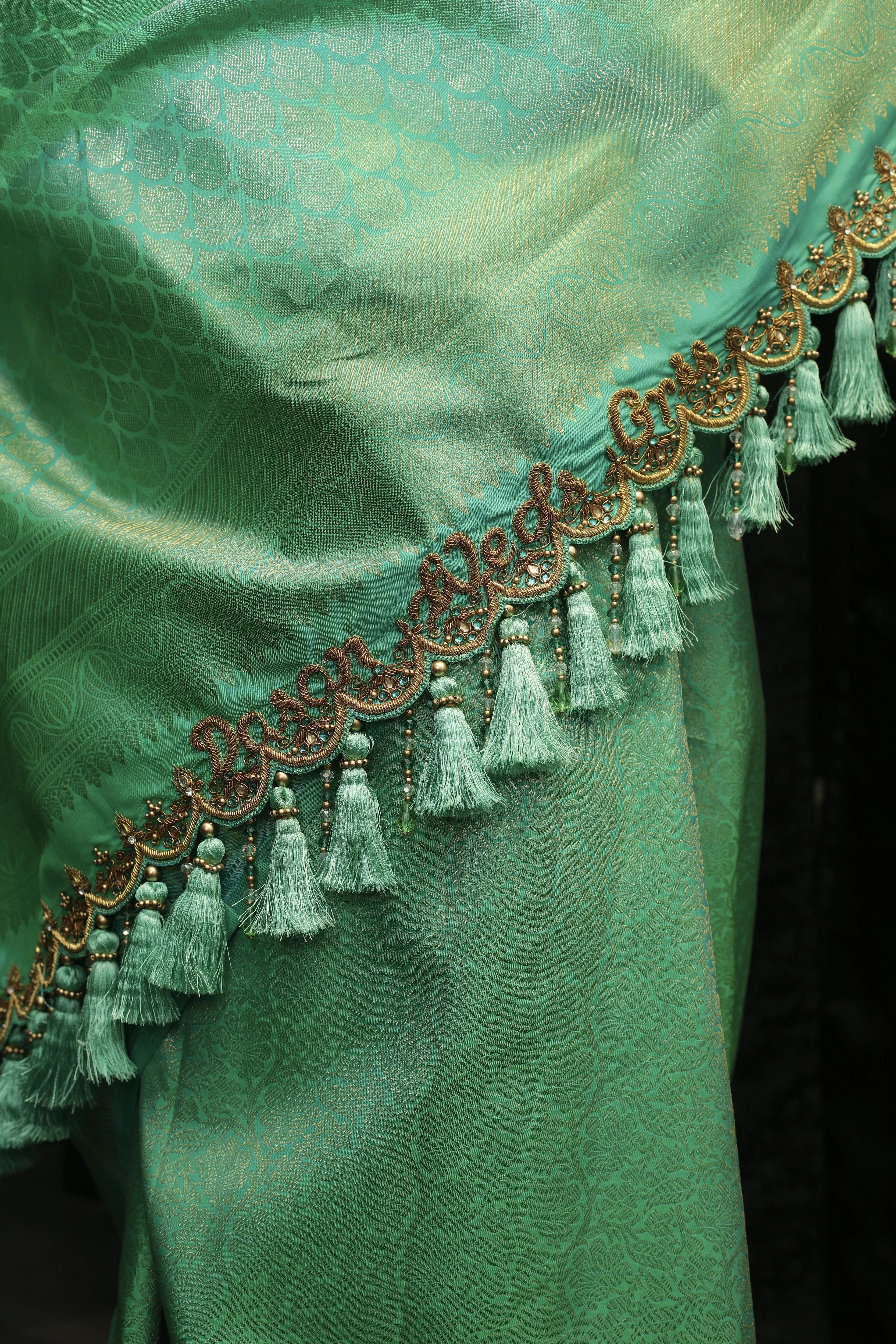 Bride Cris showcasing saree pallu design in a sea green puff sleeved silk blouse & belt, tulle veil, handcrafted with appliques, beads, kundan, stones, crystals, etc by team Archana Karthick
