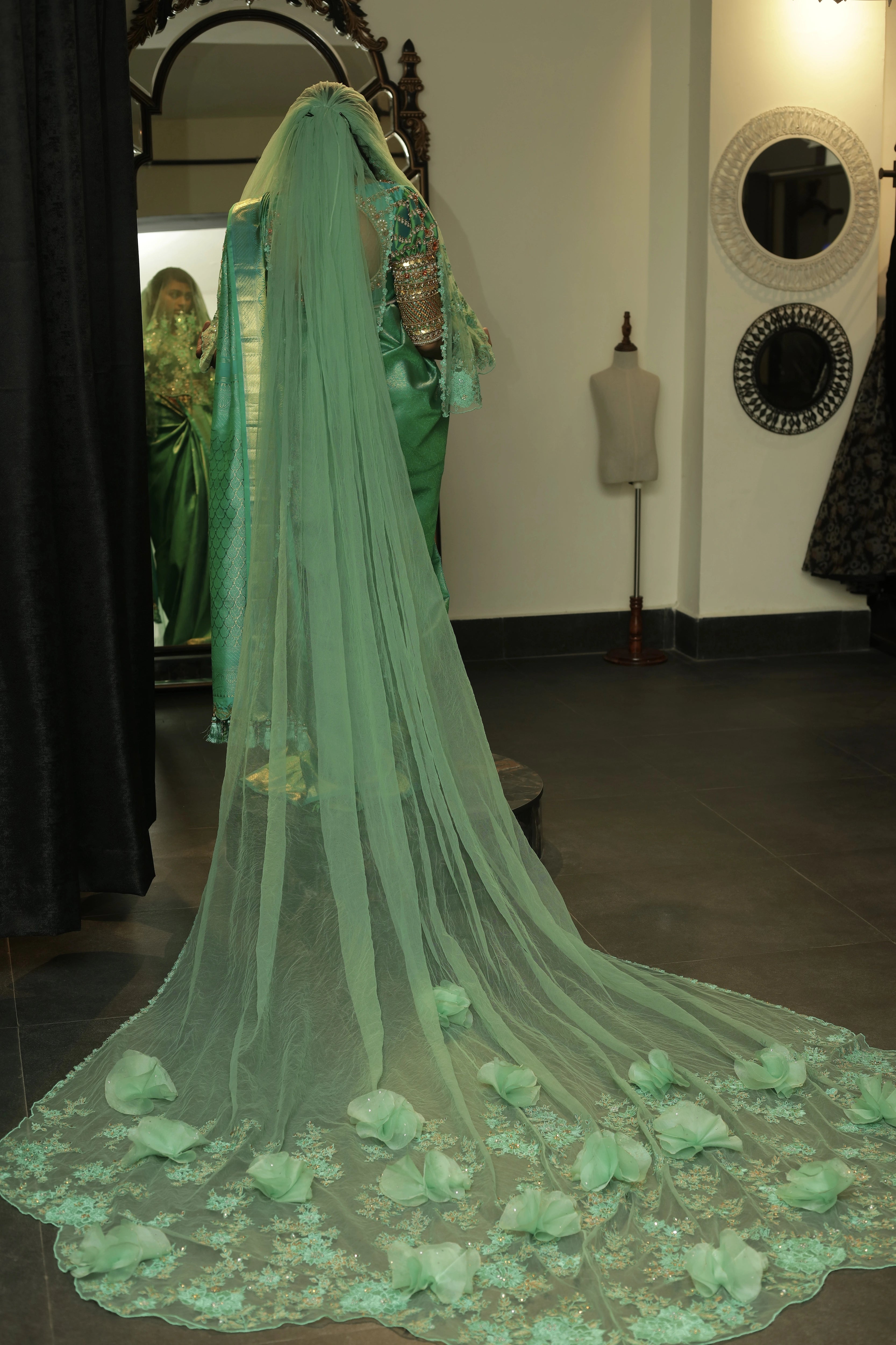 Bride Cris showcasing veil design in a sea green puff sleeved silk blouse & belt, tulle veil, handcrafted with appliques, beads, kundan, stones, crystals, etc by team Archana Karthick