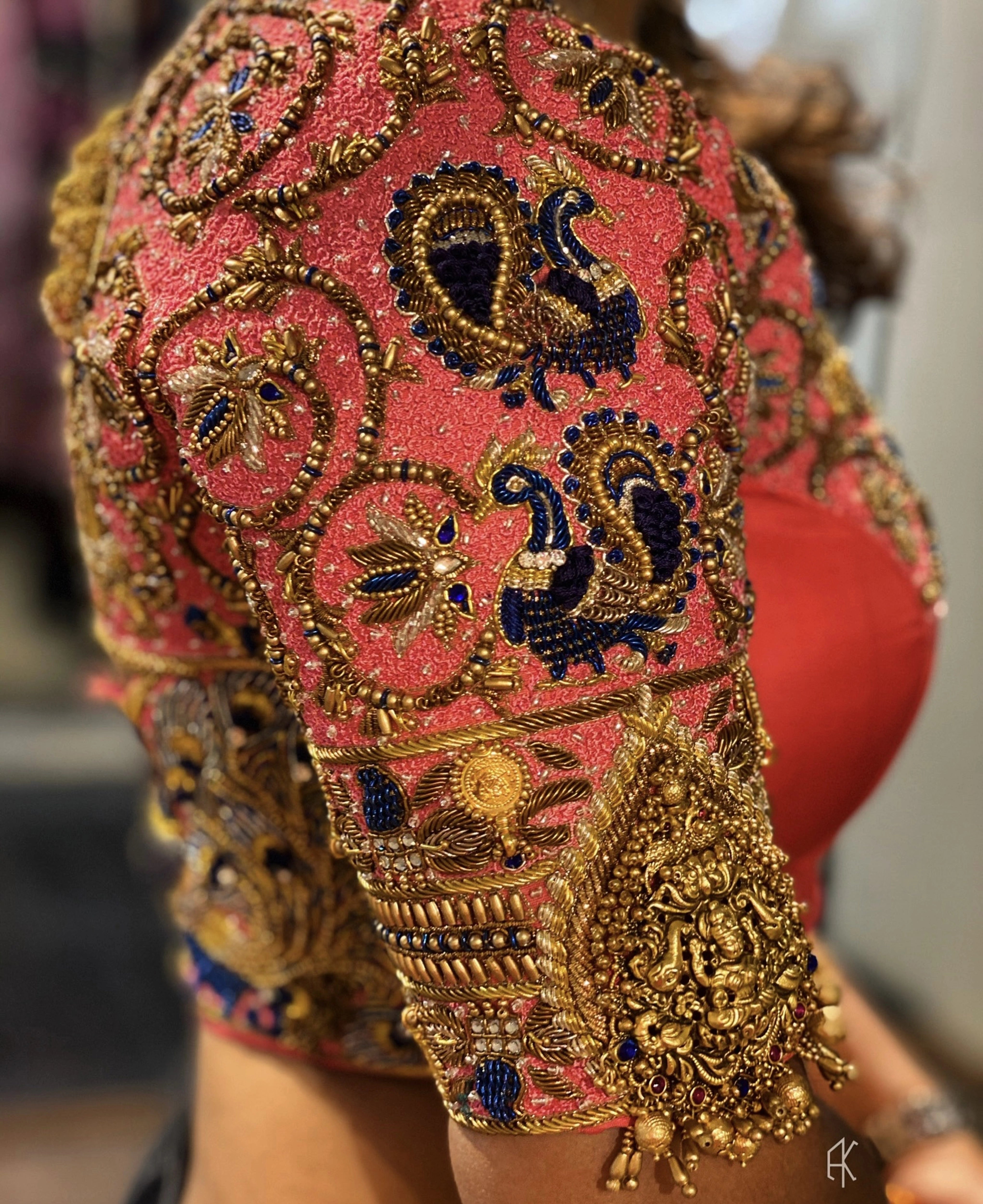 Bride Deepa showcasing blouse sleeve in a pink raw silk palanquin concept blouse, handcrafted with stones, resham, zardozi, sequins, beads, cutdana and jhumkas by team Archana Karthick.