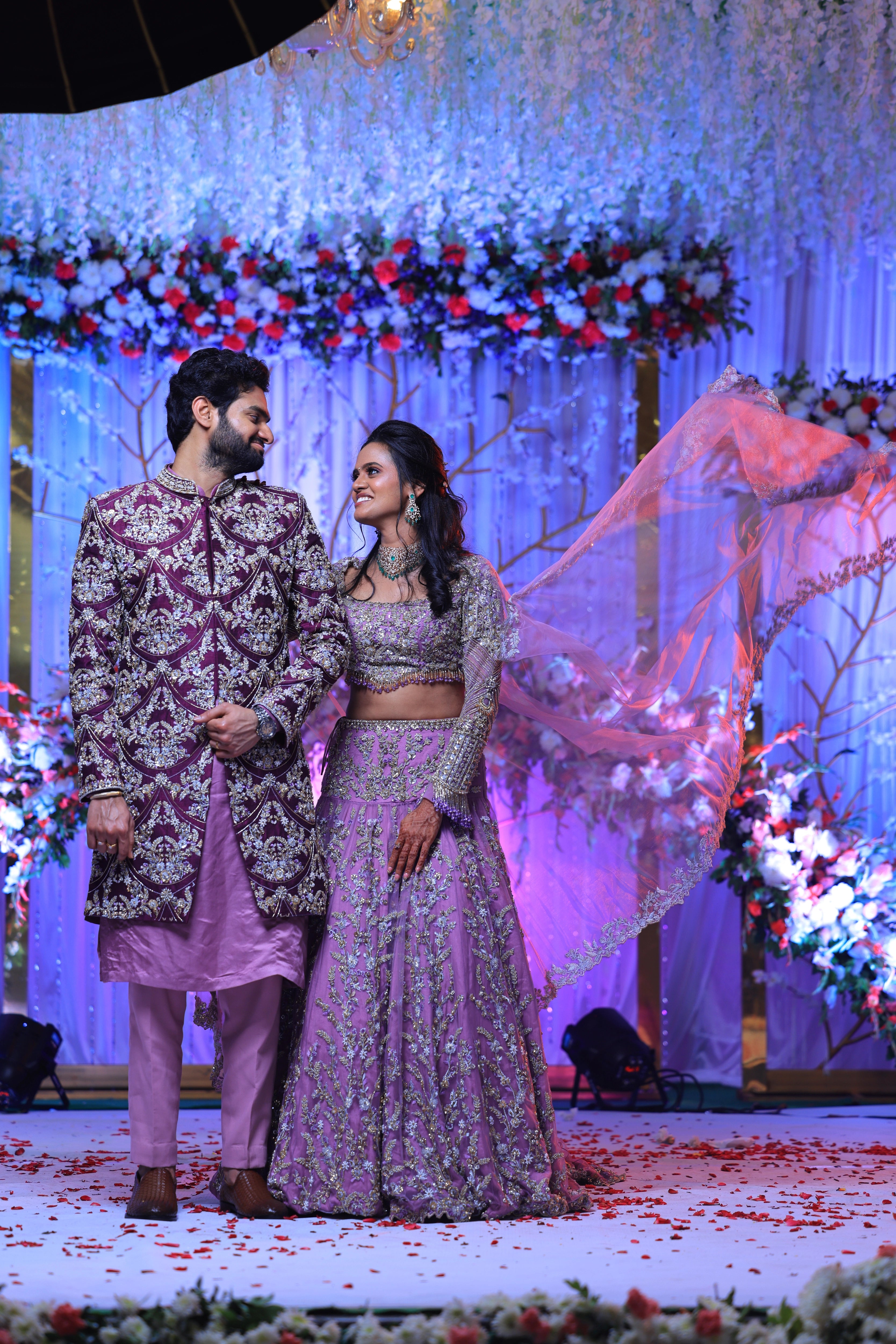 Bride Deepika laughing with groom in lavender raw silk lehenga, intricately handcrafted with sequins, cutdana, beads, crystals, rhinestones and zardozi by team Archana Karthick.