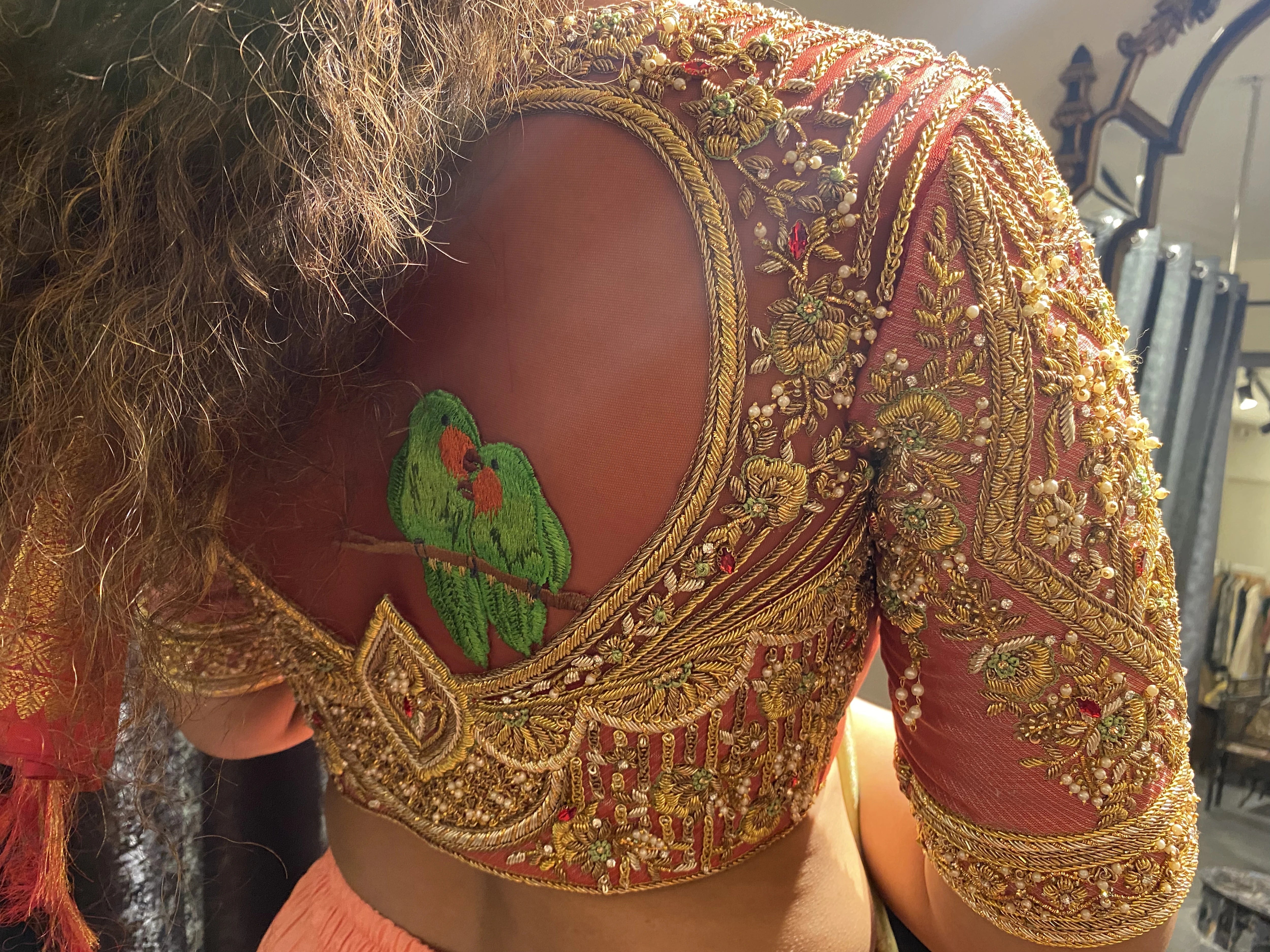 Bride Divya during fittings in a red silk blouse handcrafted by team Archana Karthick.