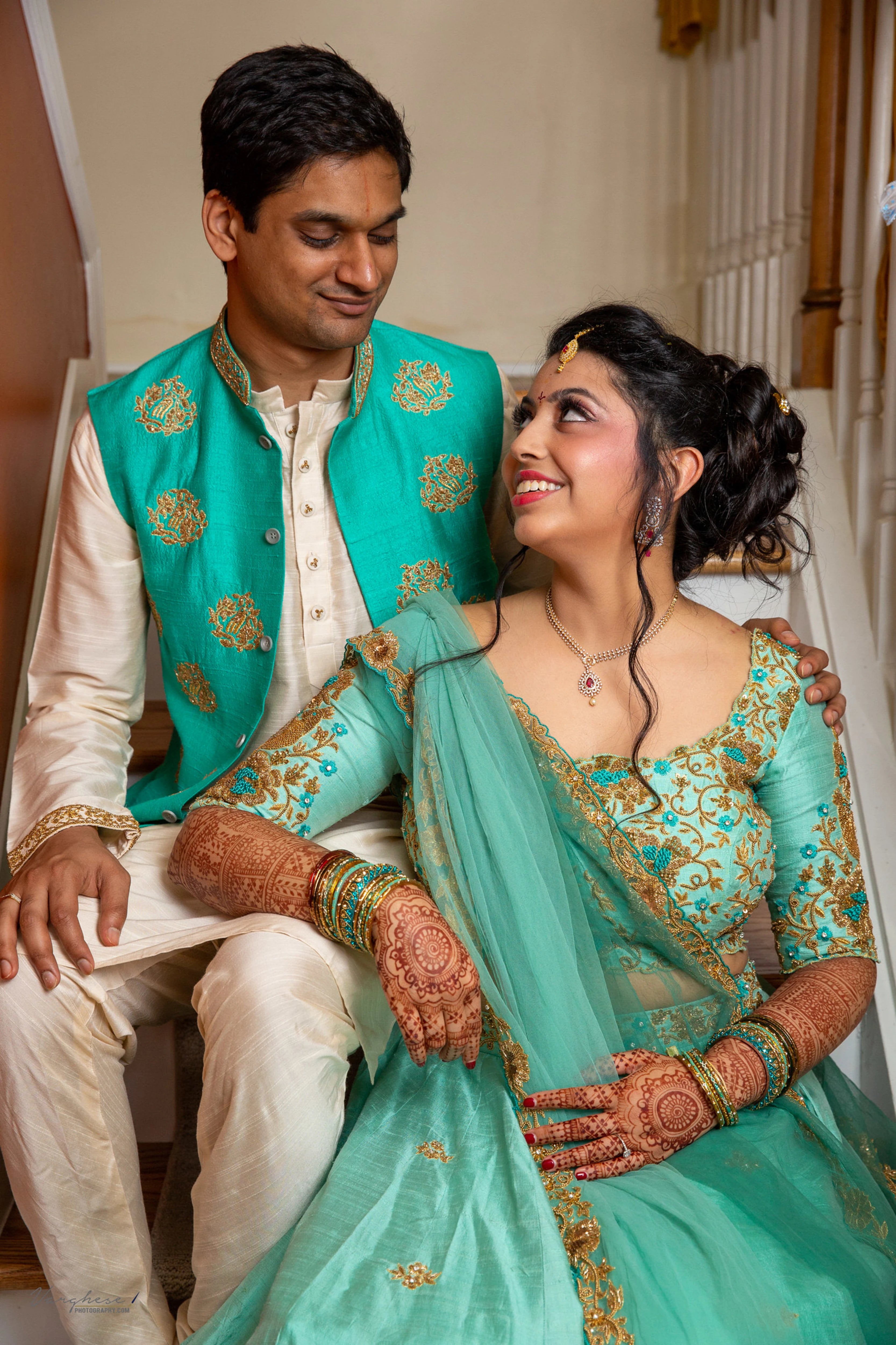 Bride & Groom from Michigan, USA, posing in a teal raw silk lehenga and bandhgala set, handcrafted by team Archana Karthick.