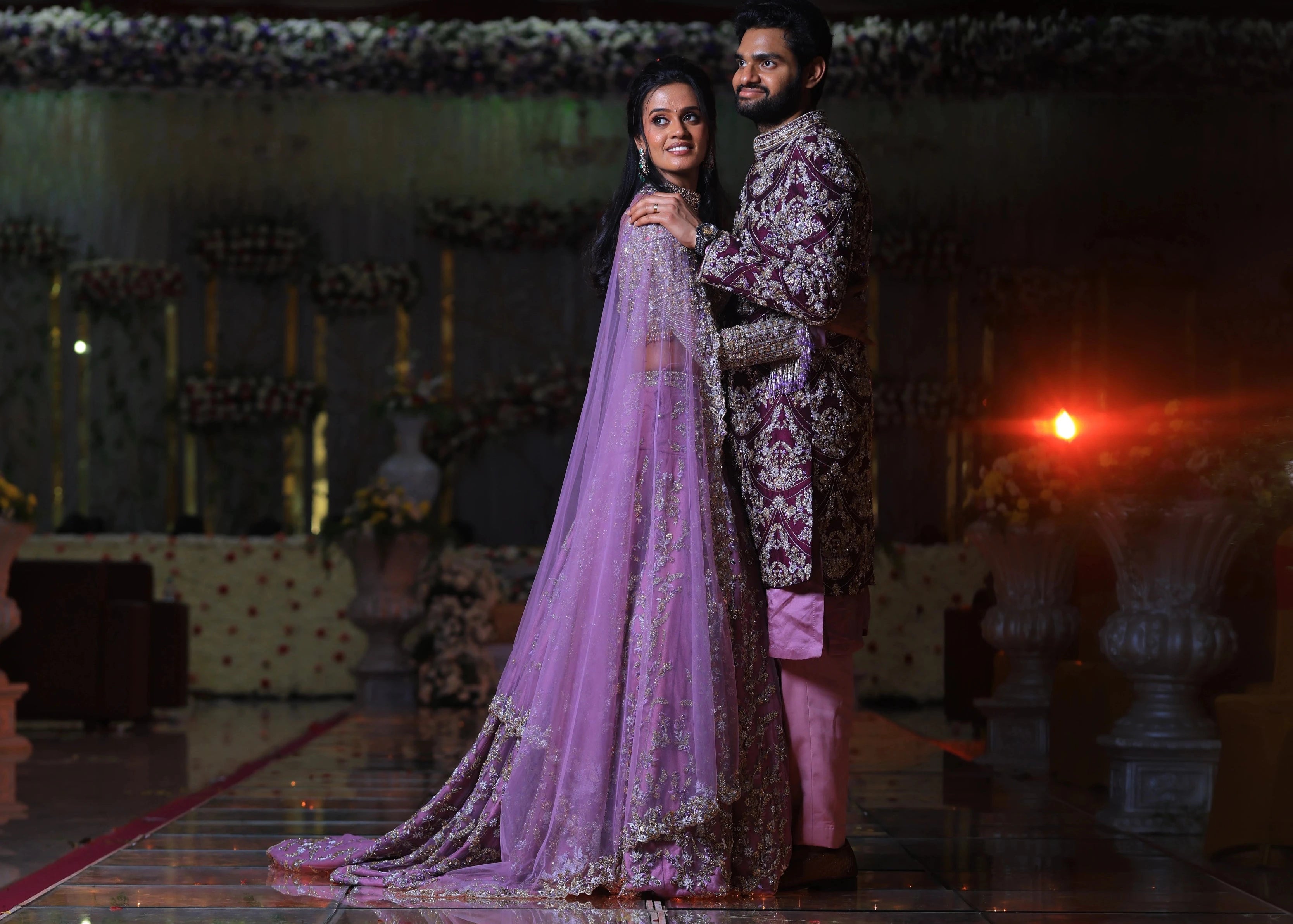 Bride & Groom posing in lavender raw silk lehenga and sherwani, handcrafted with sequins, cutdana, beads, crystals, rhinestones and zardozi by Archana Karthick
