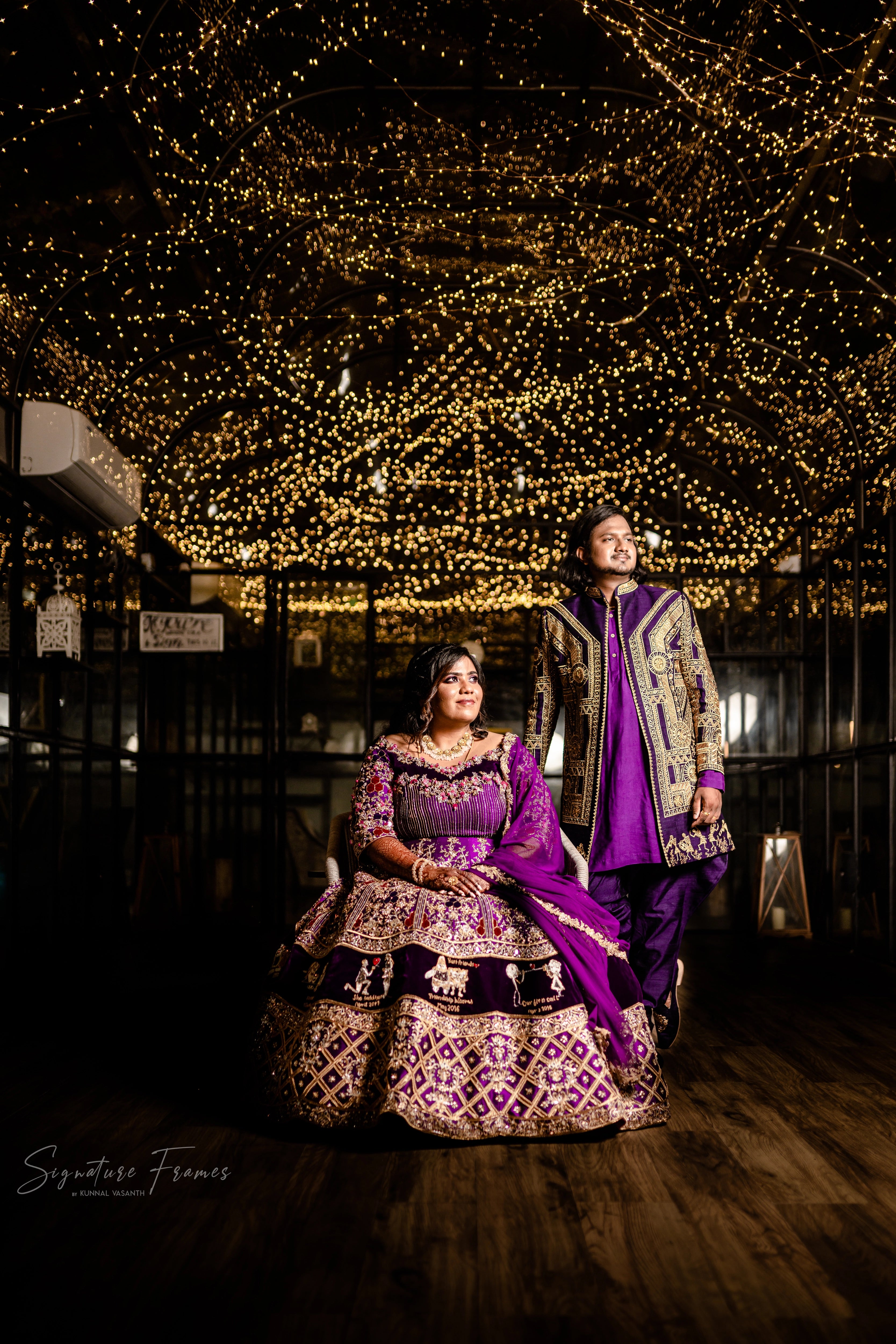 Bride & Groom smiling in a purple raw silk lehenga and navy Indowestern outfit, handcrafted with mirrors, sequins, cutdana, beads and appliques by team Archana Karthick