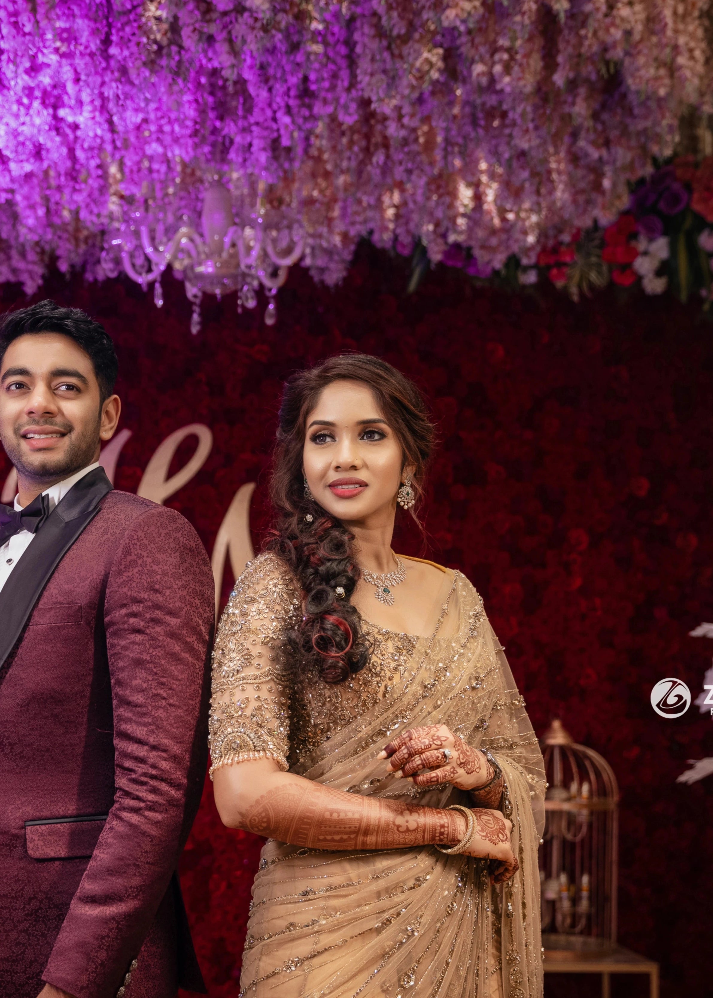 Bride Harine from San francisco posing on stage in a gold tulle saree, handcrafted with rhinestones, zardozi, sequins, crystals, cutdana and stones by team Archana Karthick.