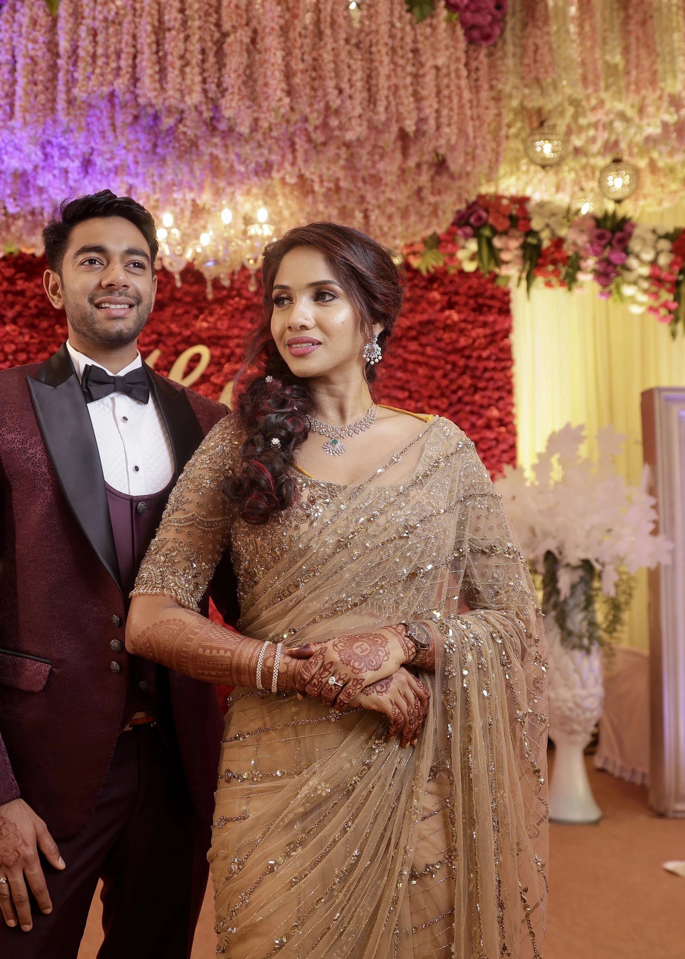 Bride Harine from San francisco smiling with groom in a gold tulle saree, handcrafted with rhinestones, zardozi, sequins, crystals, cutdana and stones by team Archana Karthick.