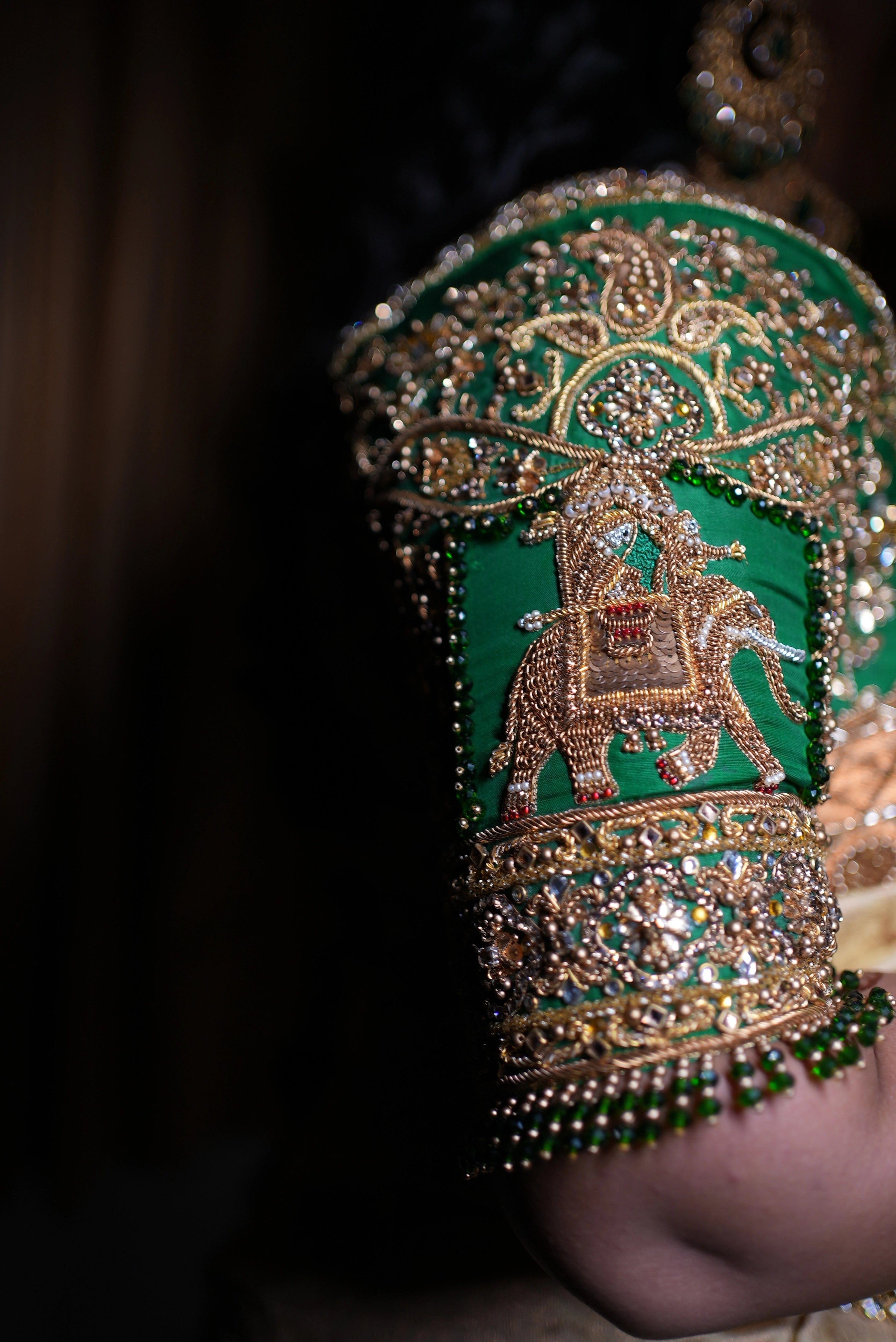 Bride Hemakiruthika from Chennai posing in a green raw silk blouse and gold silk saree with heavy border embellishments, designed by Archana Karthick.