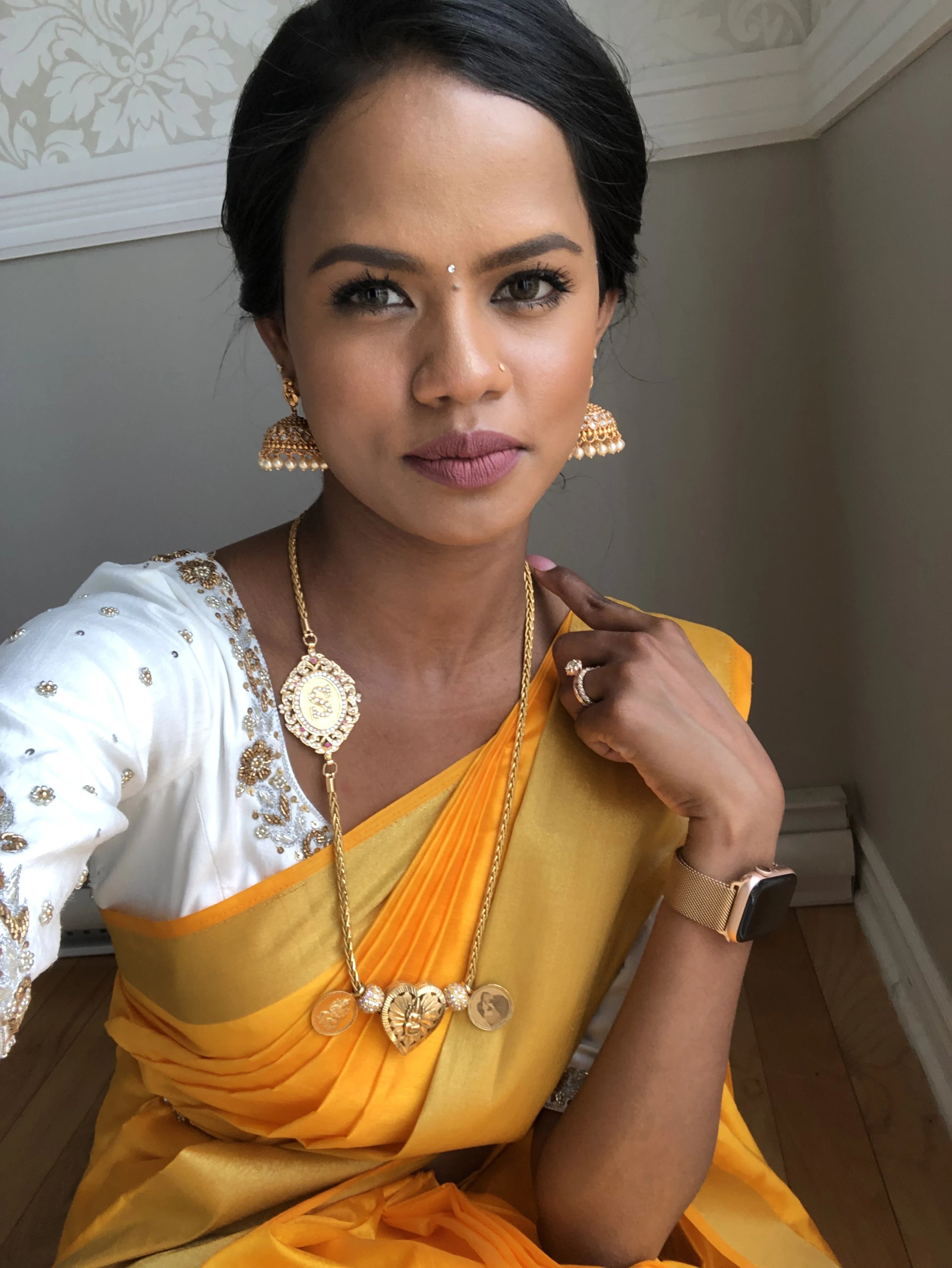 Bride Hemini from Canada, smiling in a white raw silk blouse handcrafted by team Archana Karthick.