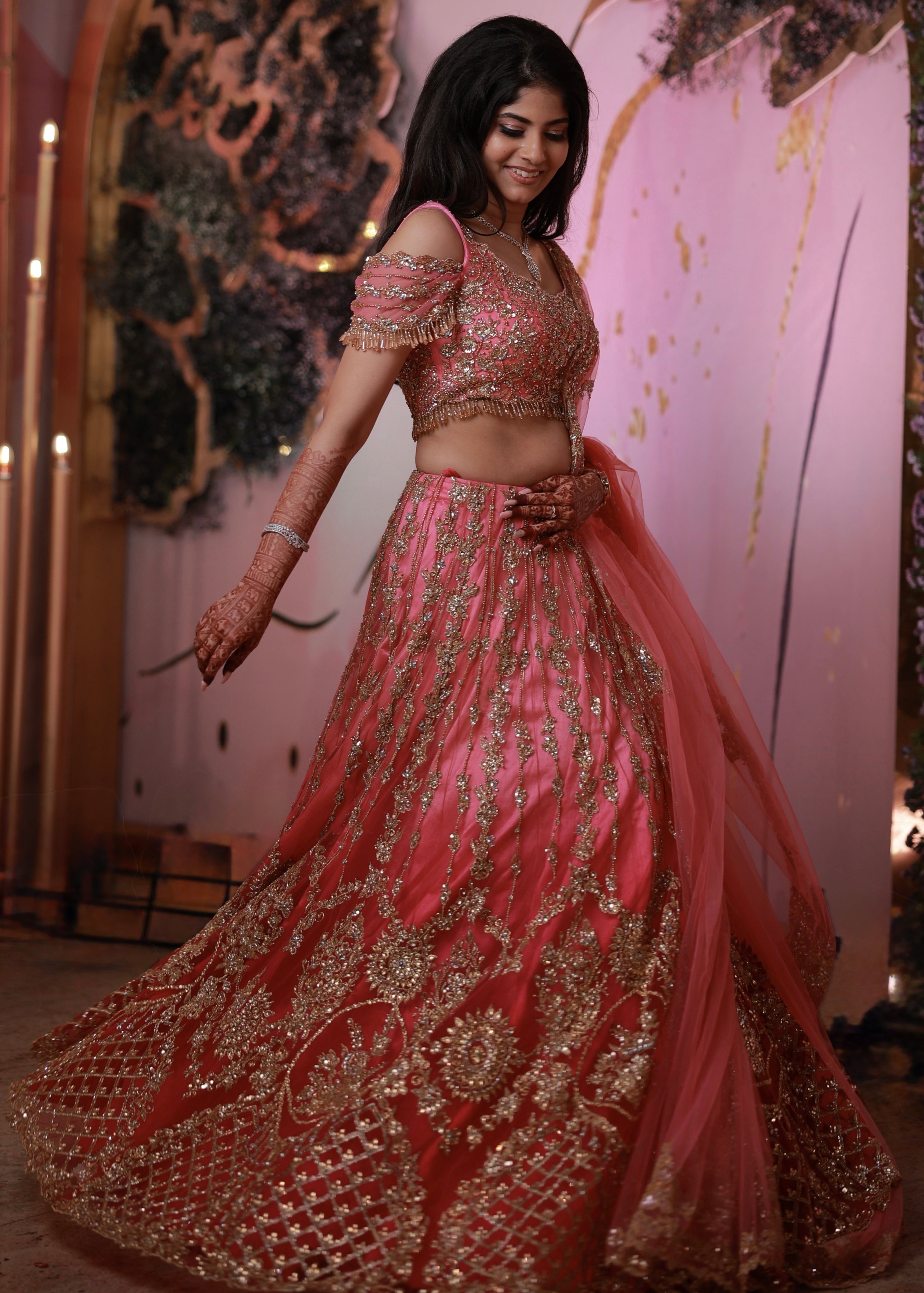Bride Kaviya from Christchurch, New Zealand twirling elegantly in her pink handcrafted reception lehenga with heavy stone work designed by Archana Karthick. Side blouse and lehnega design is captured well.