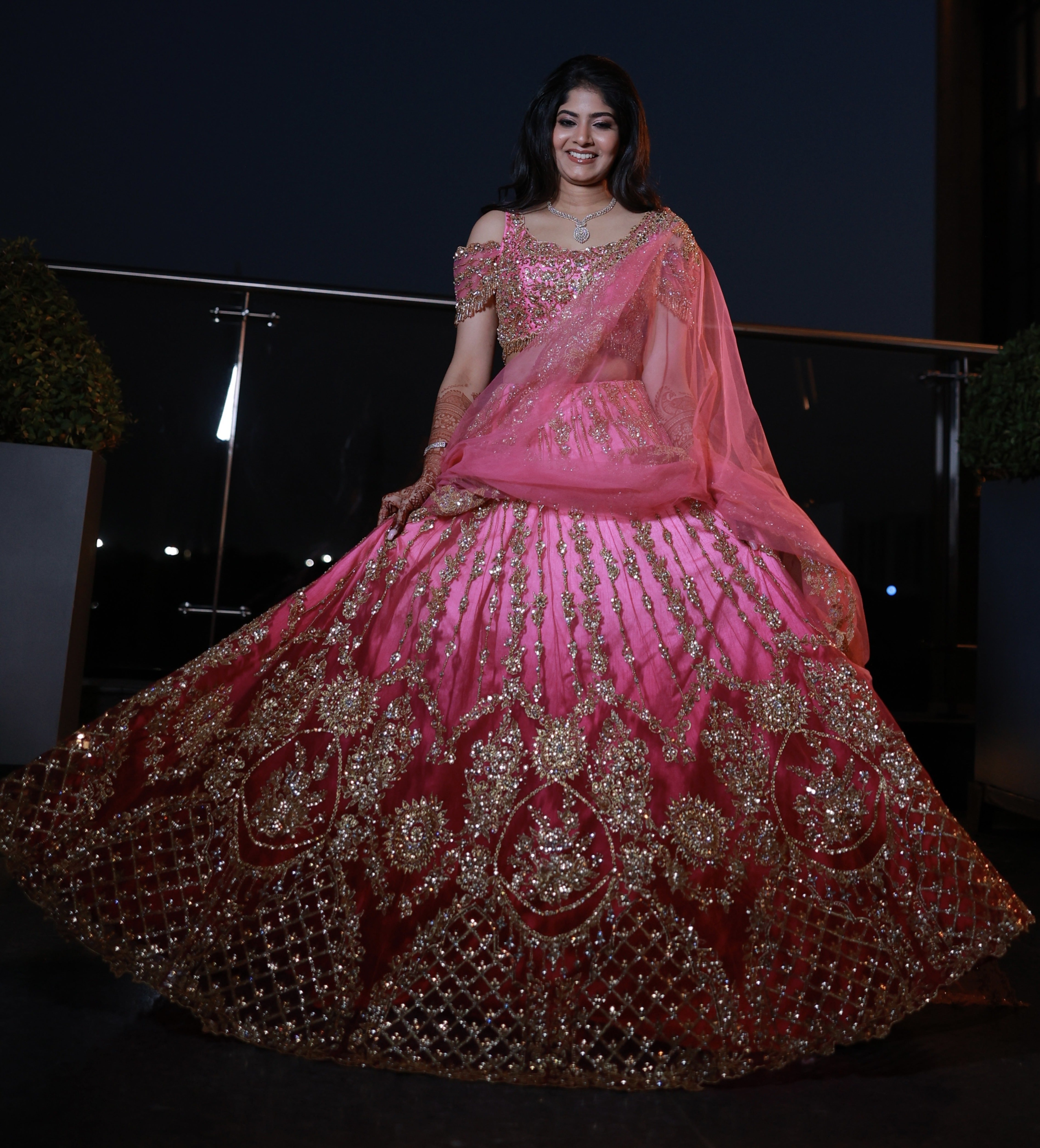Bride Kaviya from Christchurch, New Zealand twirls happily in her pink handcrafted reception lehenga with heavy stone work designed by Archana Karthick
