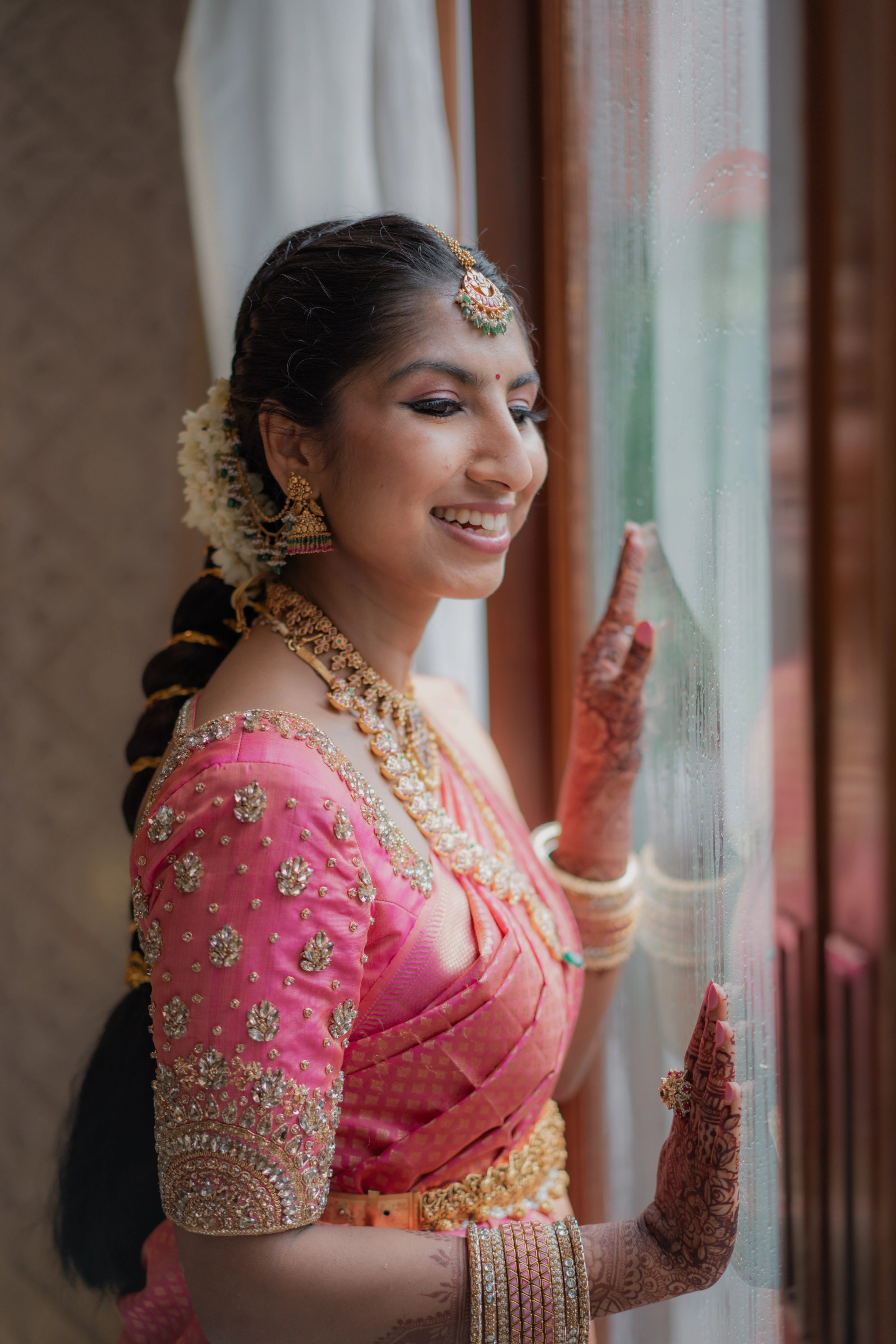 Bride Kavya in a pink raw silk blouse handcrafted by team Archana Karthick.