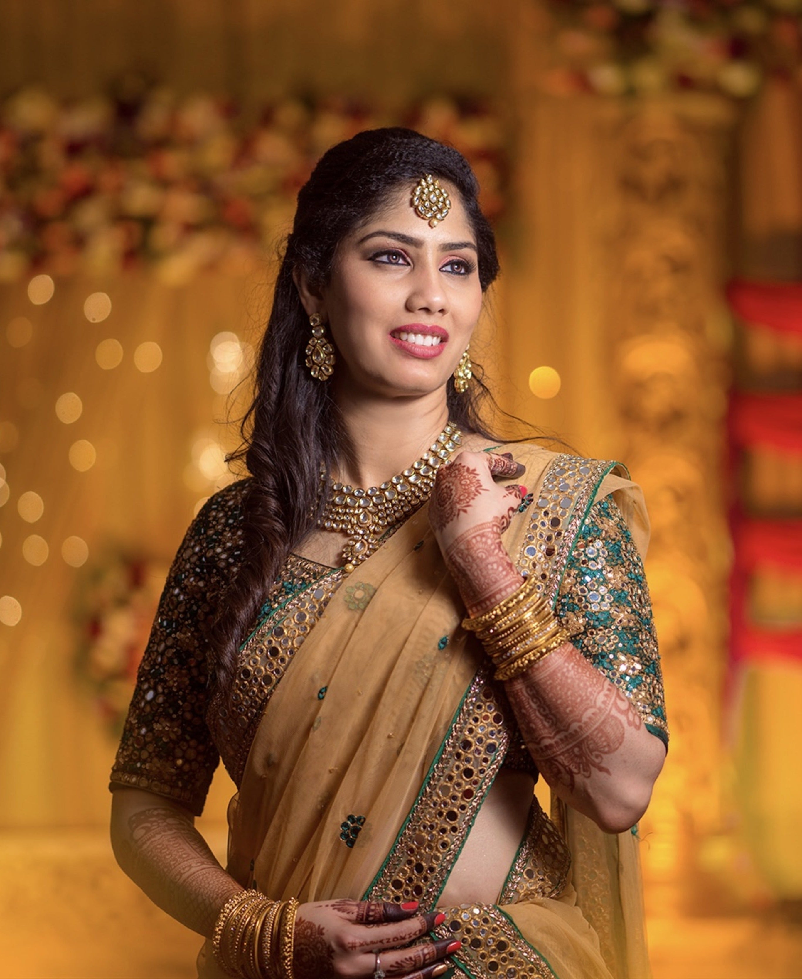 Bride Keerthana, from new zealand in a green handcrafted love story lehenga by Archana Karthick. Closeup shot of her looking away from the camera