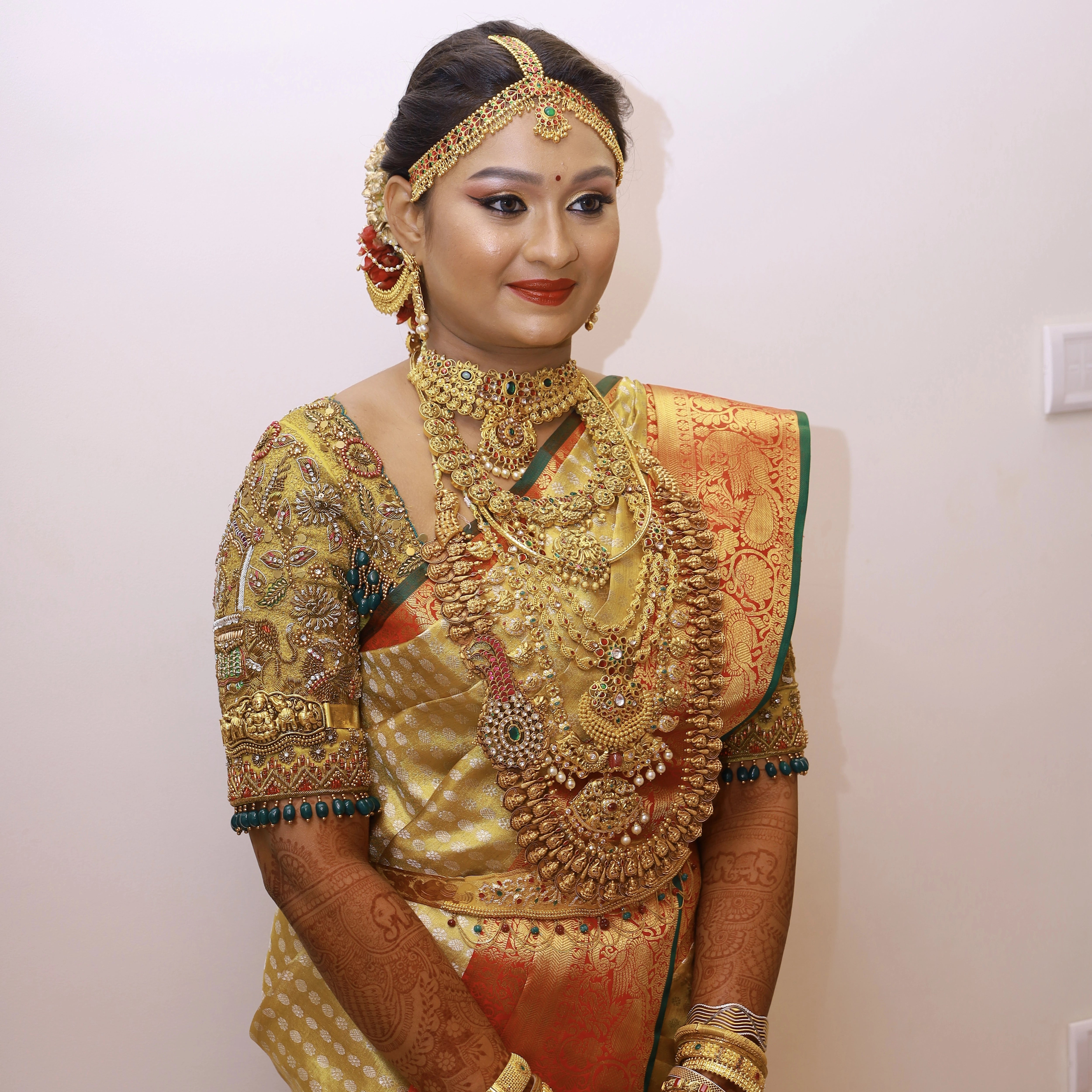 Bride Krithika Balan in gold silk palanquin concept blouse, intricately handcrafted with zardozi, coins, resham, kemp stones and beads by team Archana Karthick.