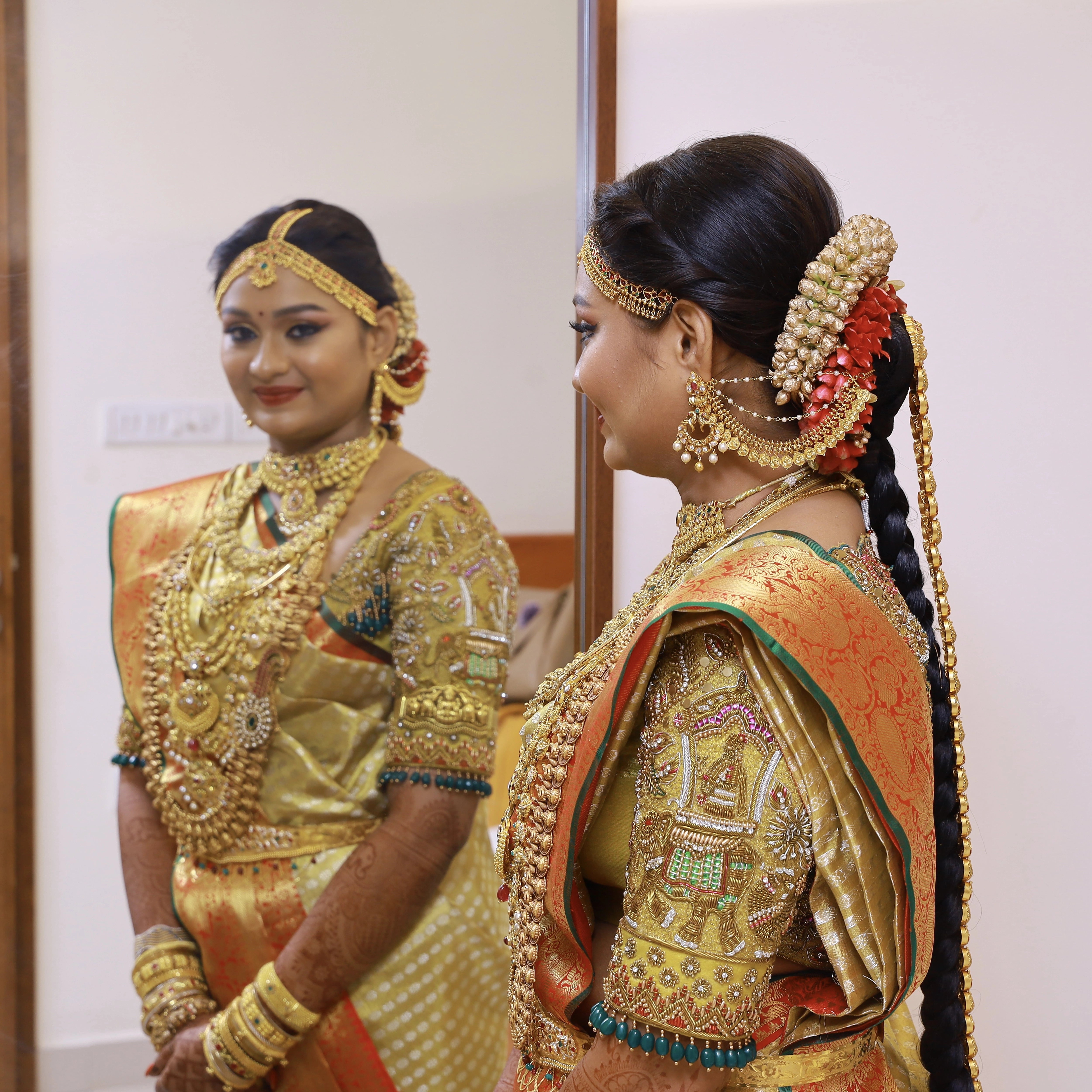 Bride Krithika Balan showcasing sleeve in gold silk palanquin concept blouse, intricately handcrafted with zardozi, coins, resham, kemp stones and beads by team Archana Karthick.