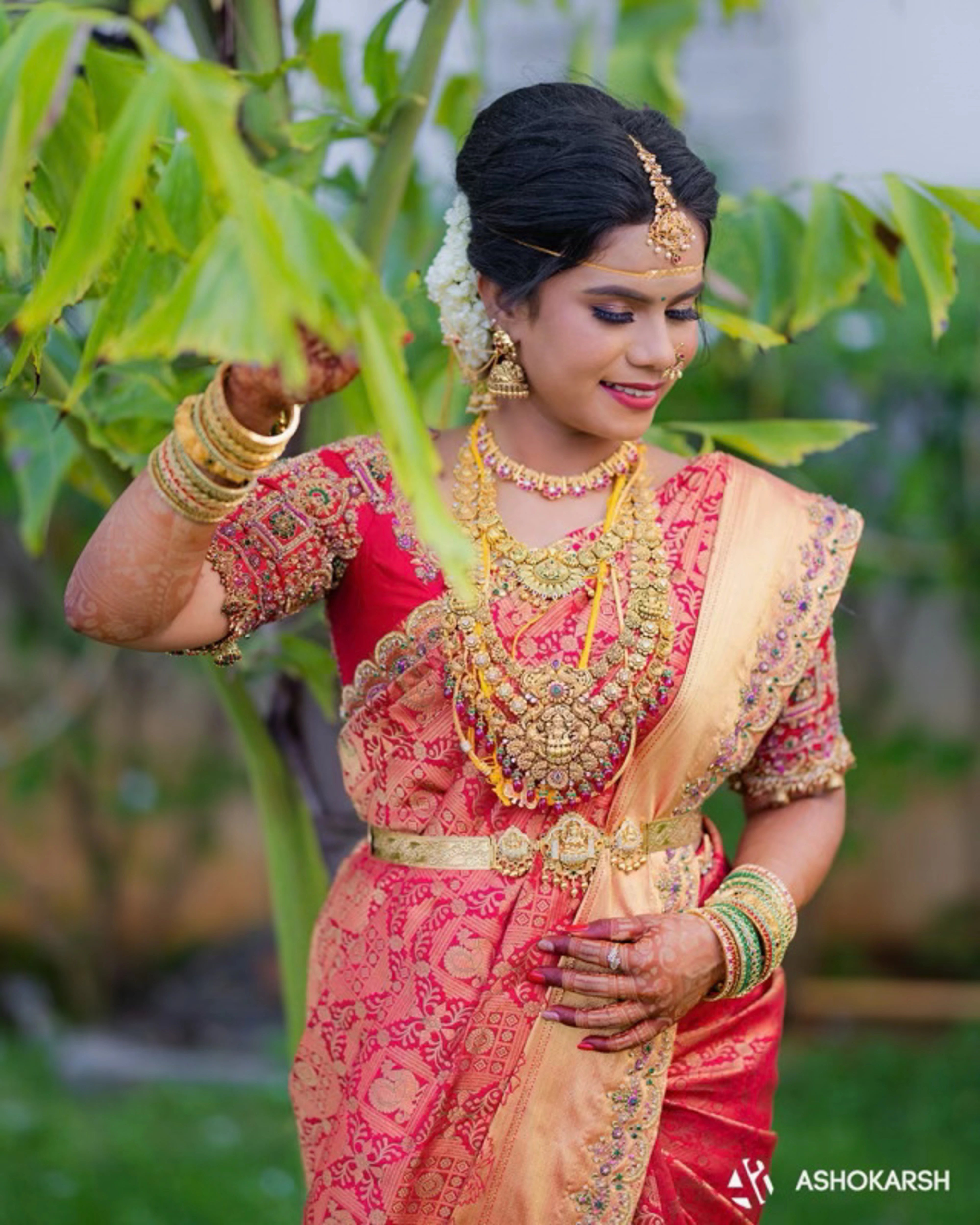 Bride Kushmma posing in a red silk blouse & saree border by Archana Karthick