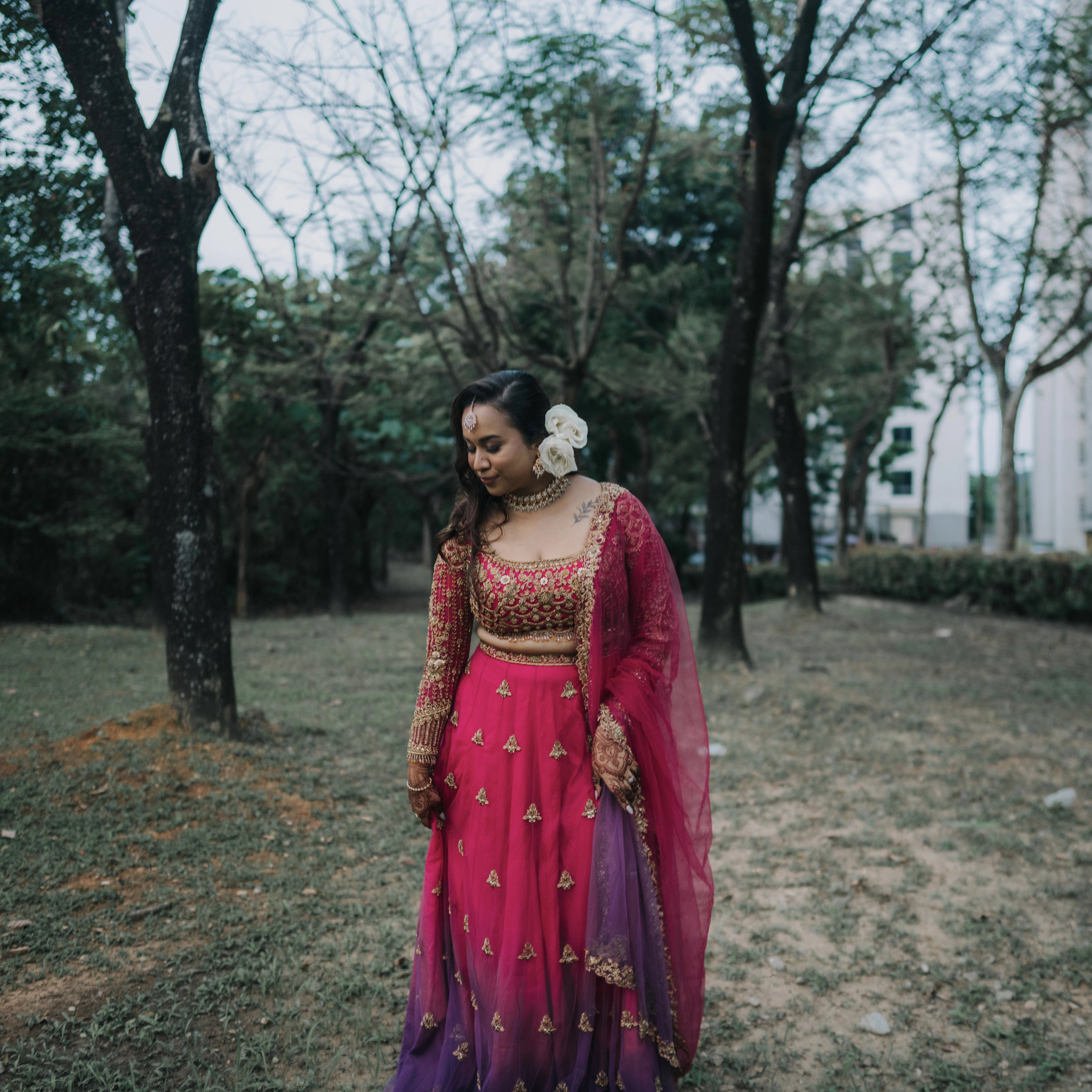 Bride Lalina from Malaysia posing outdoors in a pink & purple ombre lehnega, intricately handcrafted with zardozi, beads, sequions, knot work and crystals.