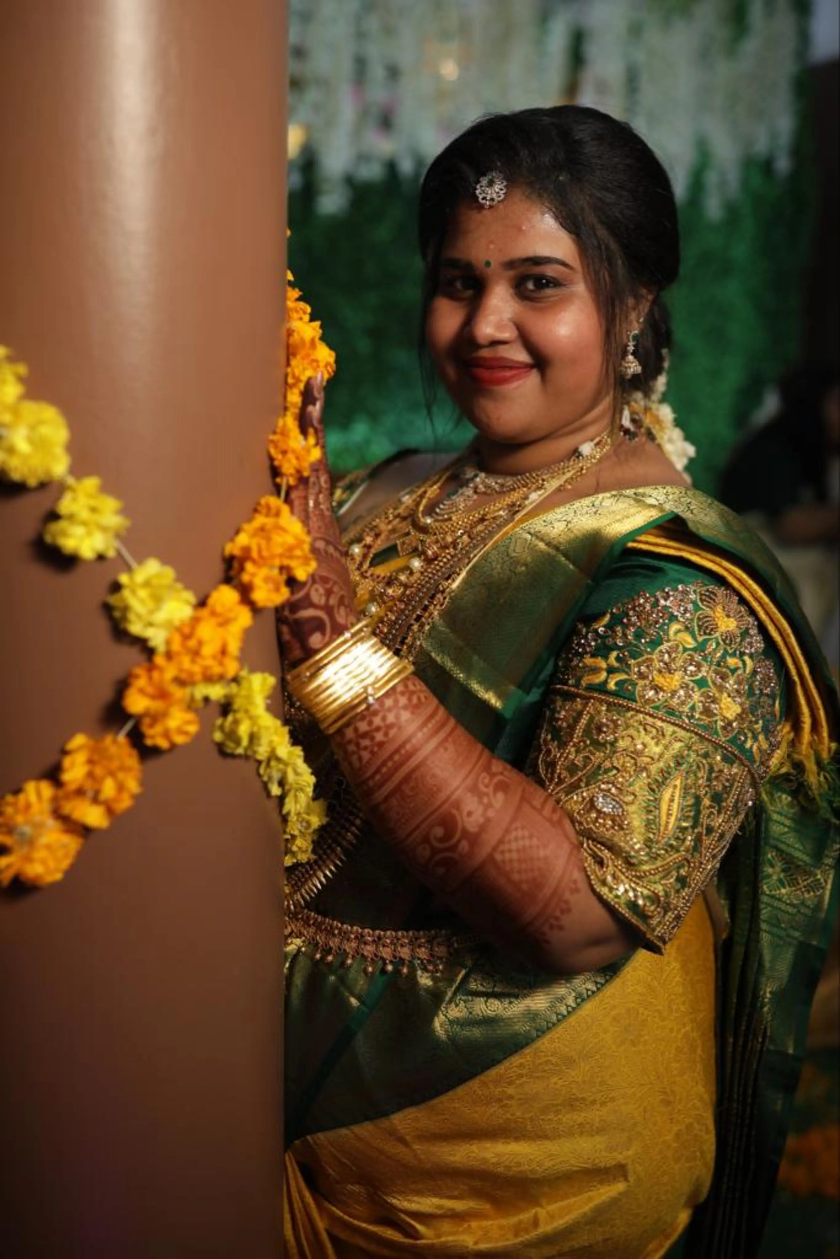 Bride Monisha from Kerala posing in a green silk blouse handcrafted by team Archana Karthick.