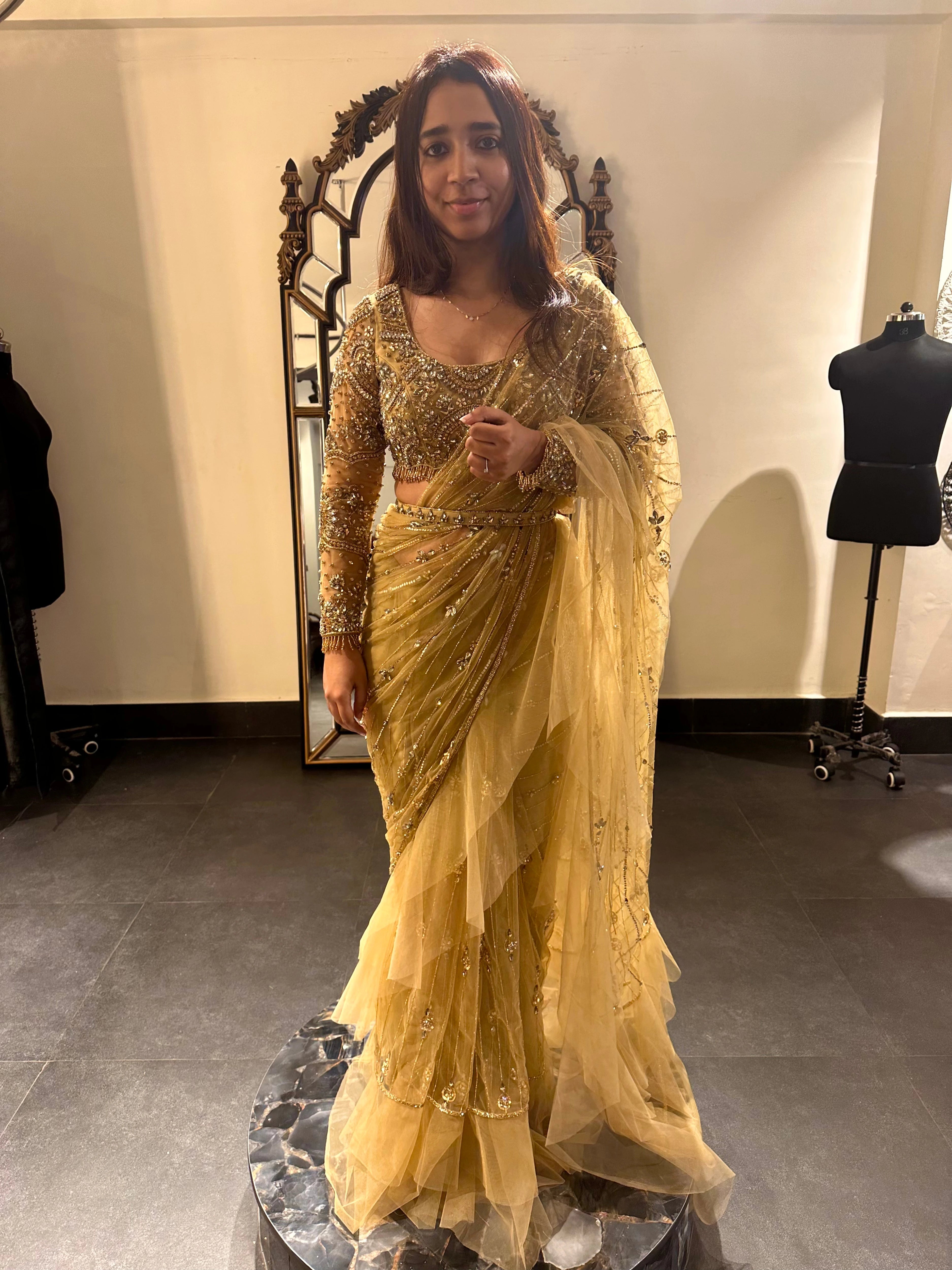 Bride Narmada smiling in a golden beige tulle saree handcrafted by team Archana Karthick.