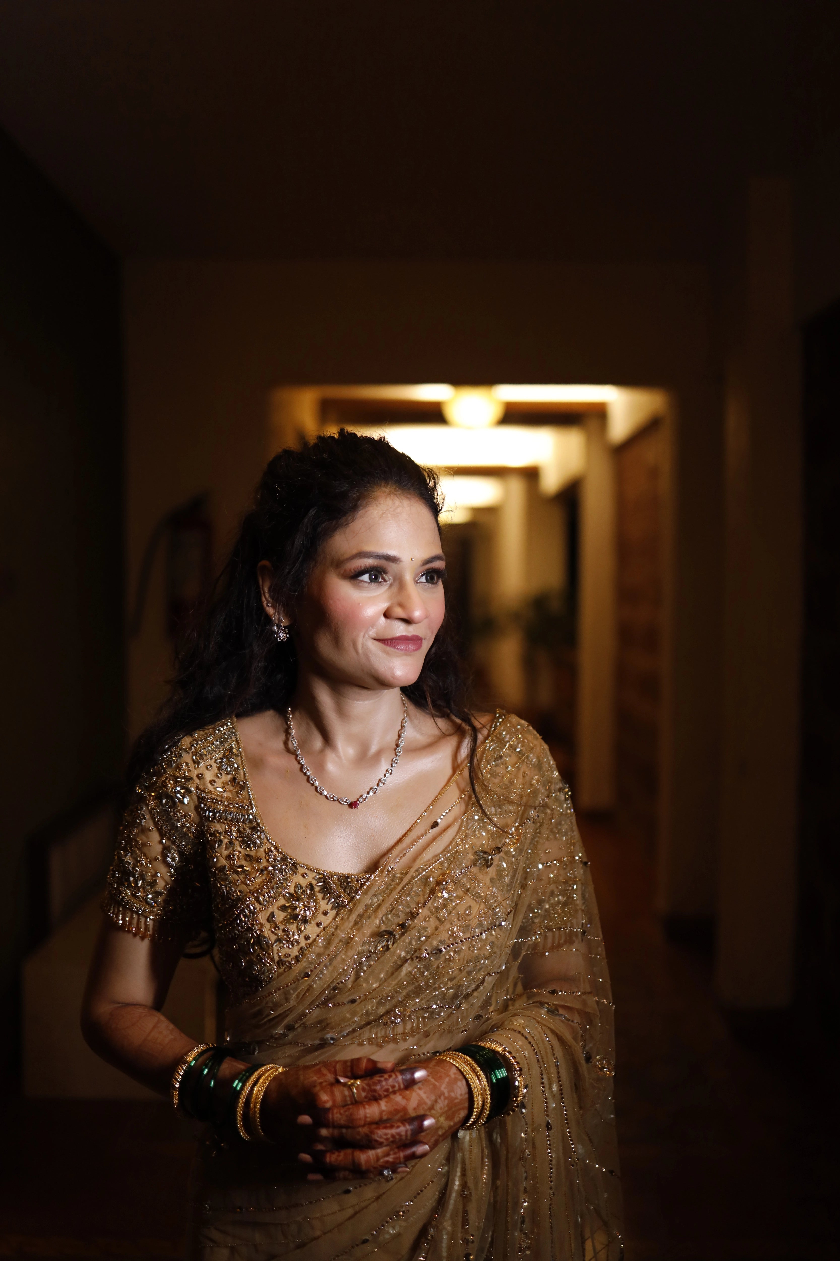 Bride Neha from Virginia, smiling in a golden tulle saree, handcrafted with rhinestones, zardozi, sequins, crystals, cutdana and stones by team Archana Karthick.
