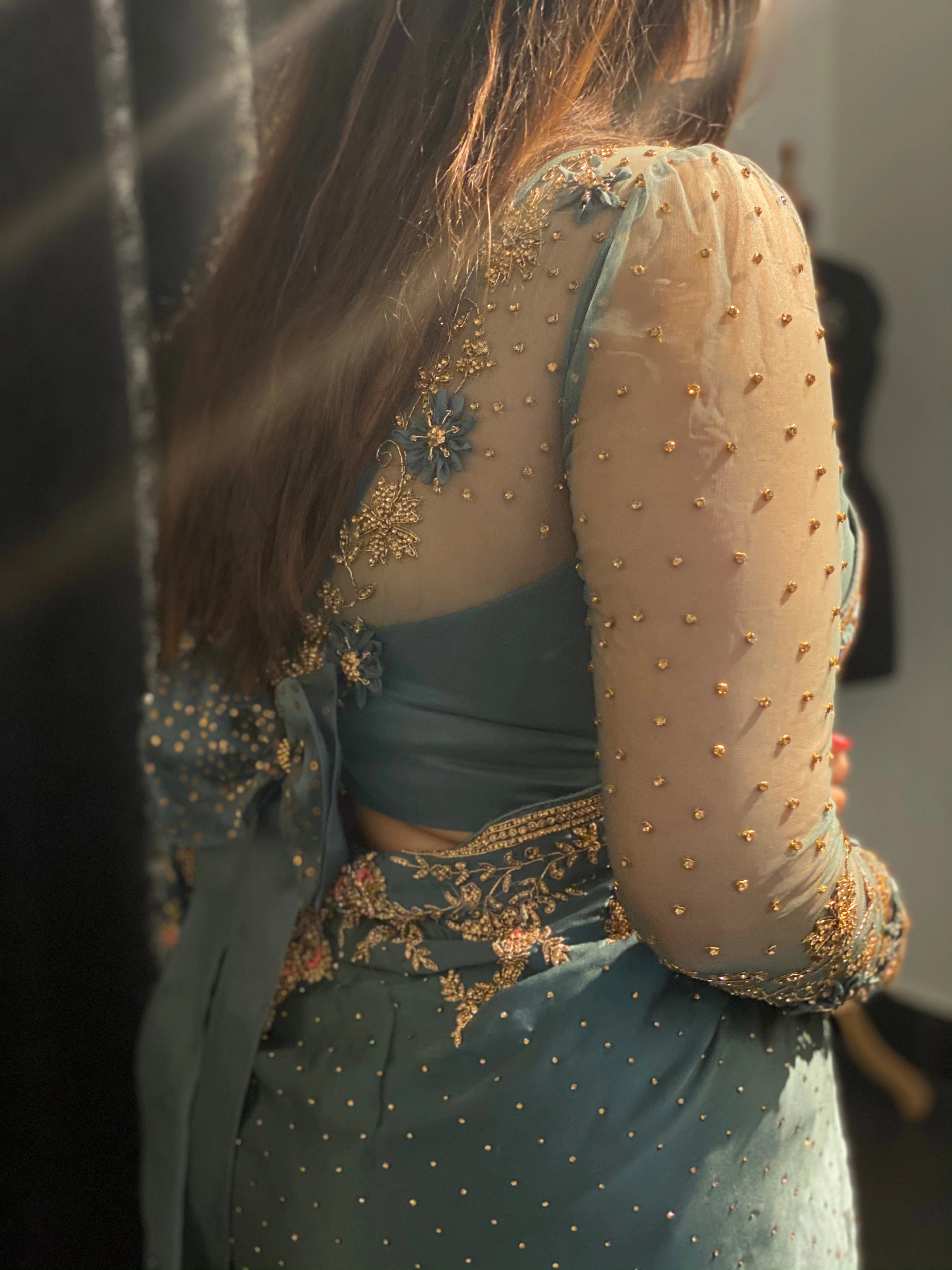 Bride Neha posing in a blue grey tulle blouse handcrafted by team Archana Karthick.