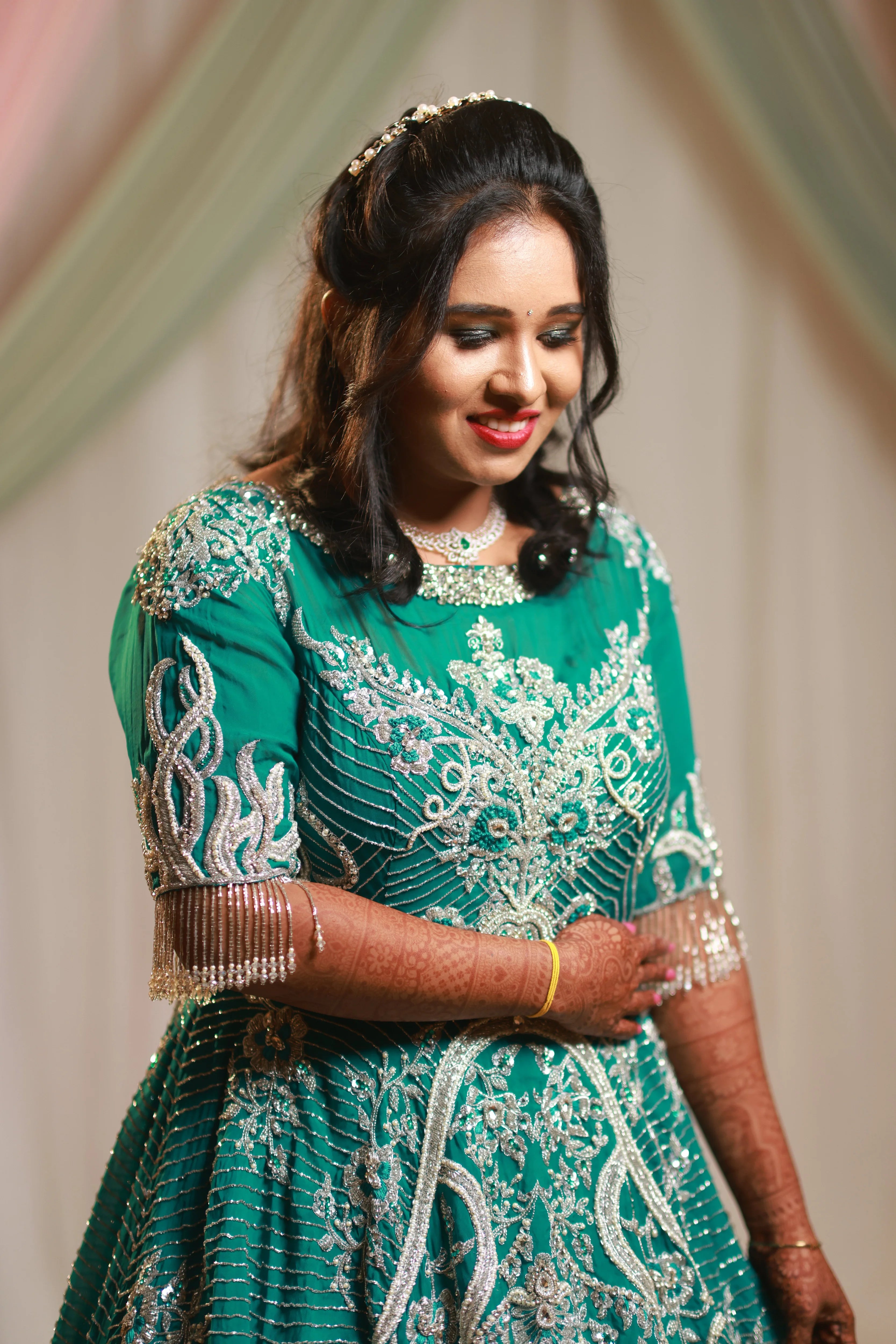 Bride Niveda from USA, posing in a teal reception gown, handcrafted by team Archana Karthick.
