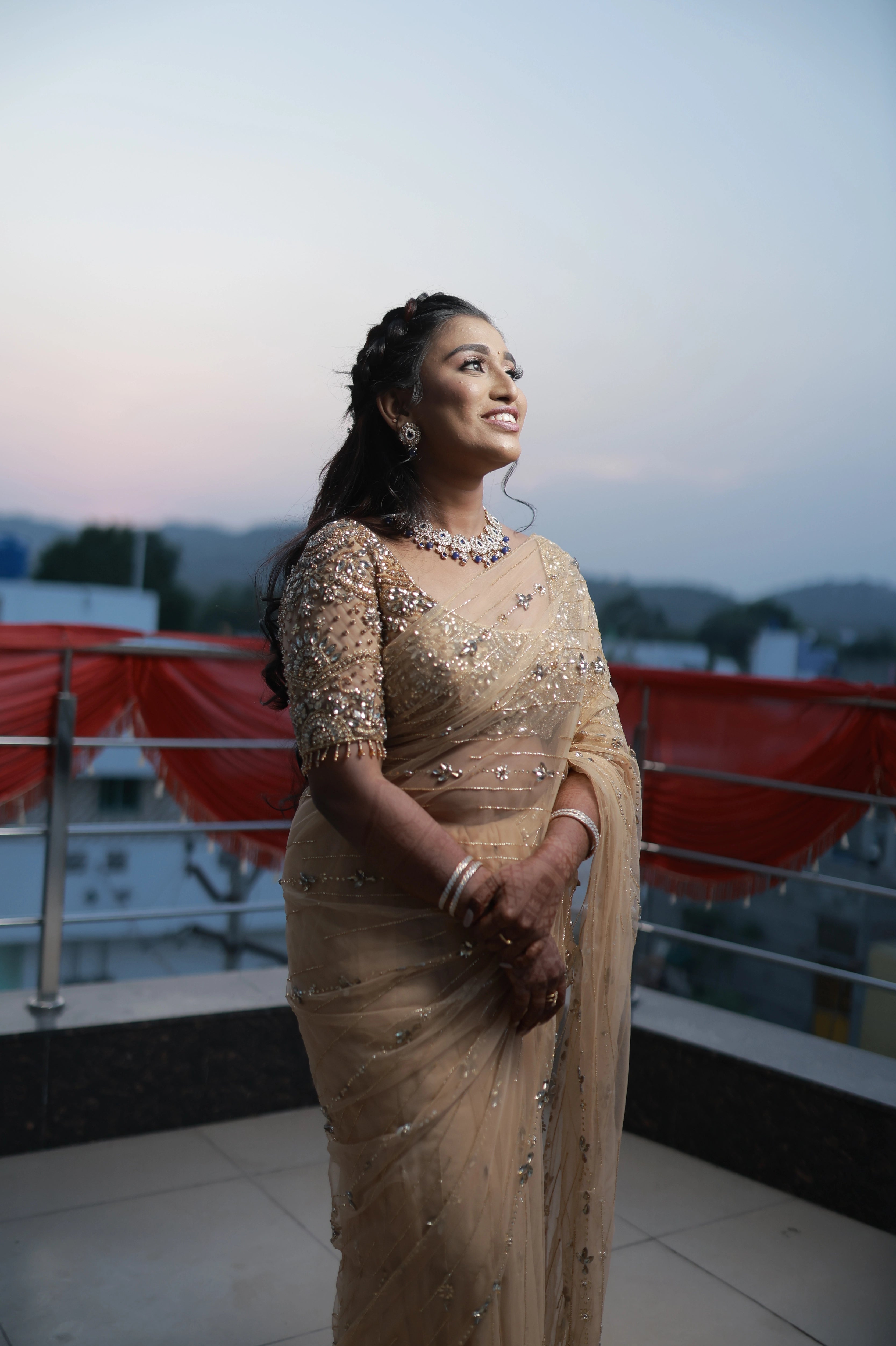 Bride Niveditha posing in a golden beige tulle saree handcrafted by team Archana Karthick.