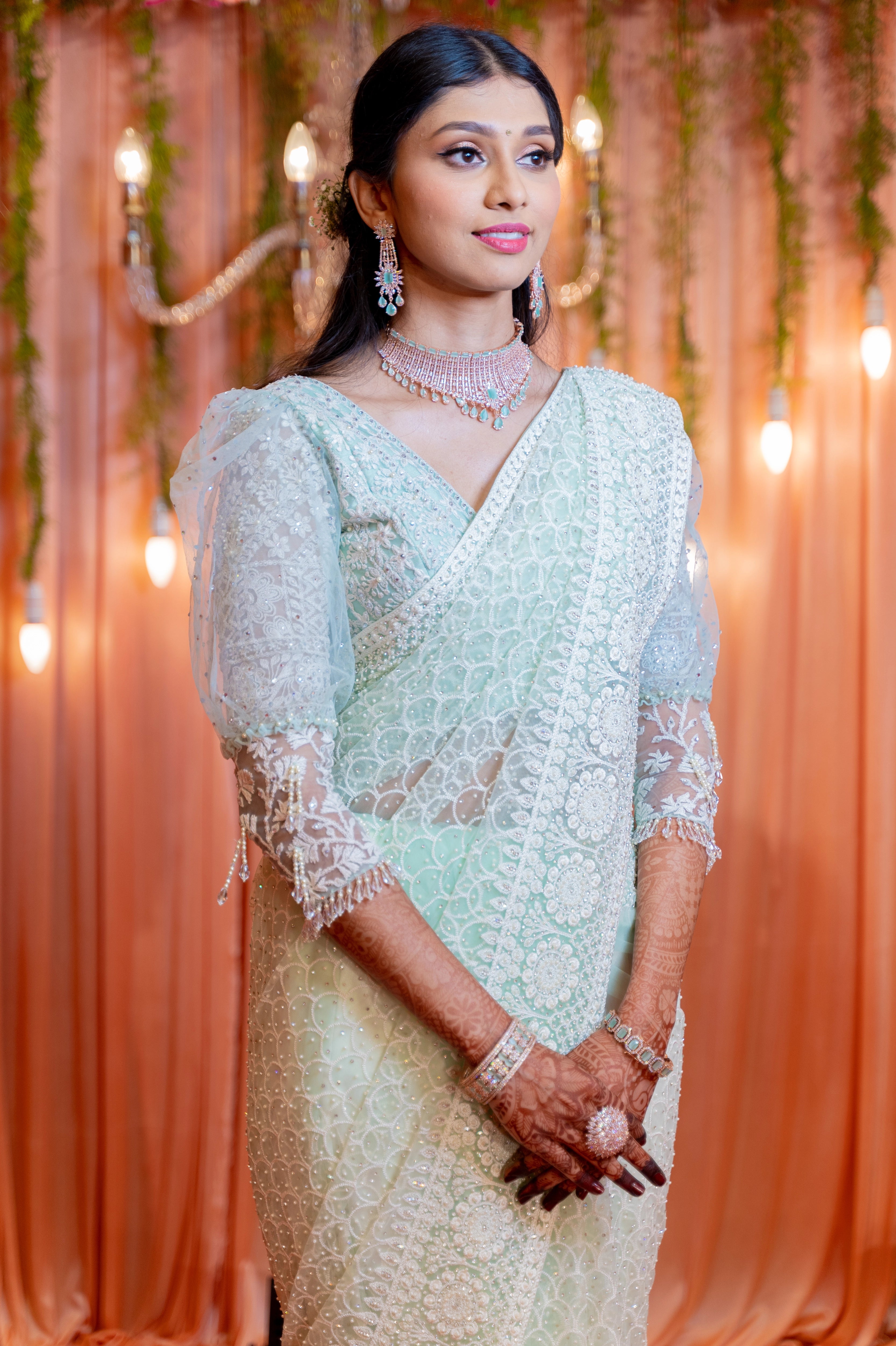 Bride Niveditha posing in a pastel mint green tulle blouse handcrafted by team Archana Karthick.