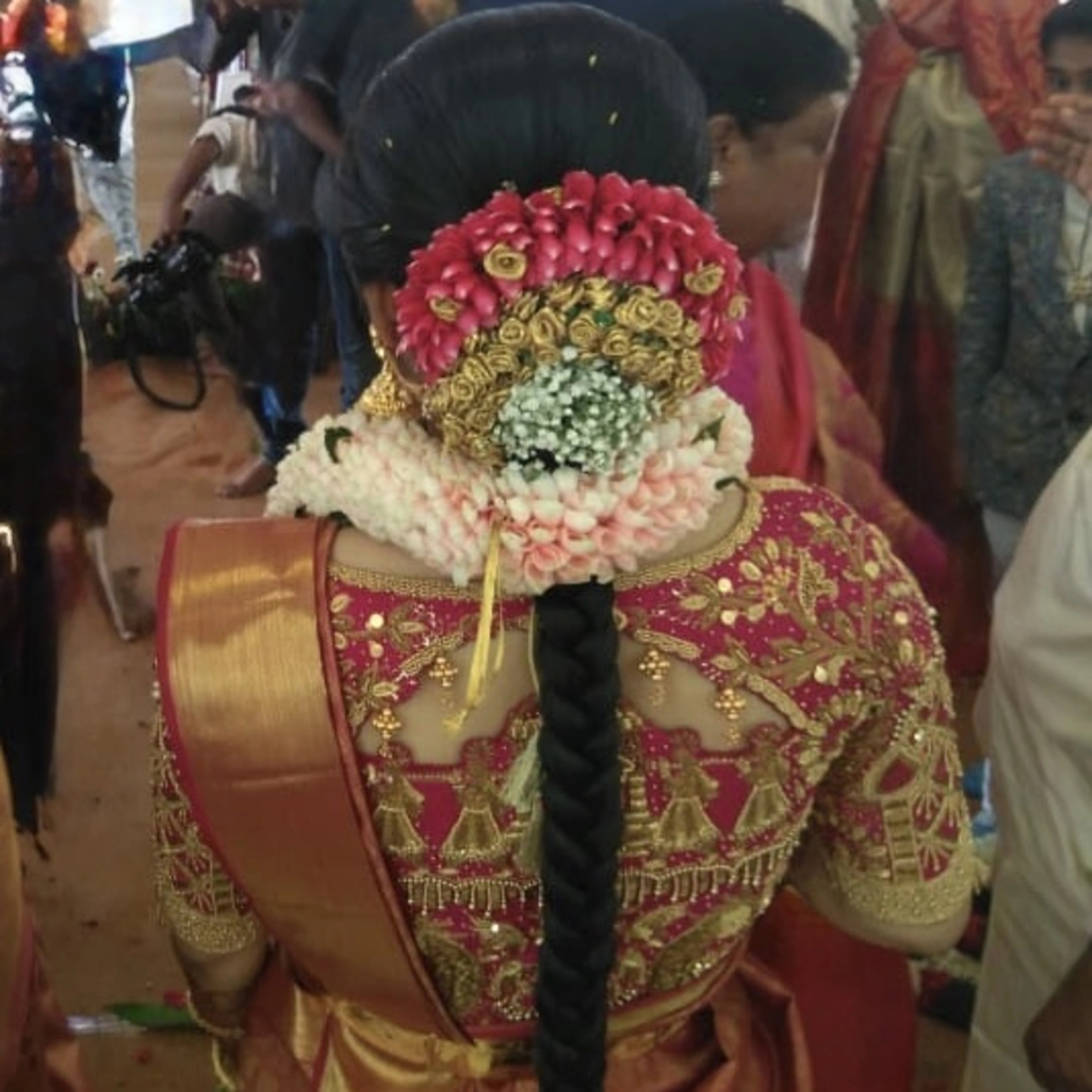 Bride Padma from Coimbatore showcasing back blouse designs in a red silk palanquin concept blouse intricately handcrafted with zardozi, stones, beads, sequins etc by team Archana Karthick.
