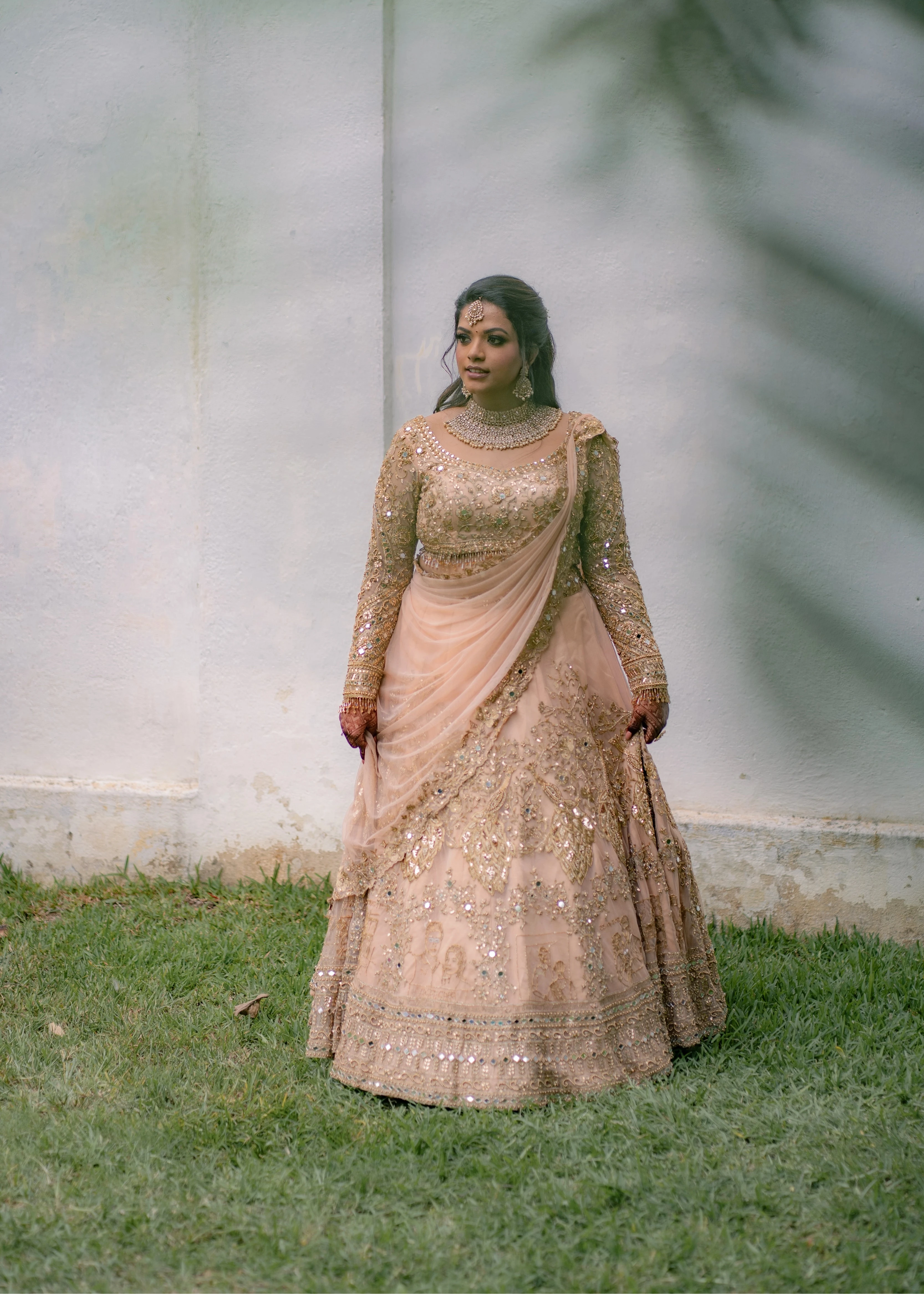 Bride Pavithra in a beige gold tulle lehenga, intricately handcrafted with mirrors, sequins, cutdana, beads, crystals and resham by team Archana Karthick.