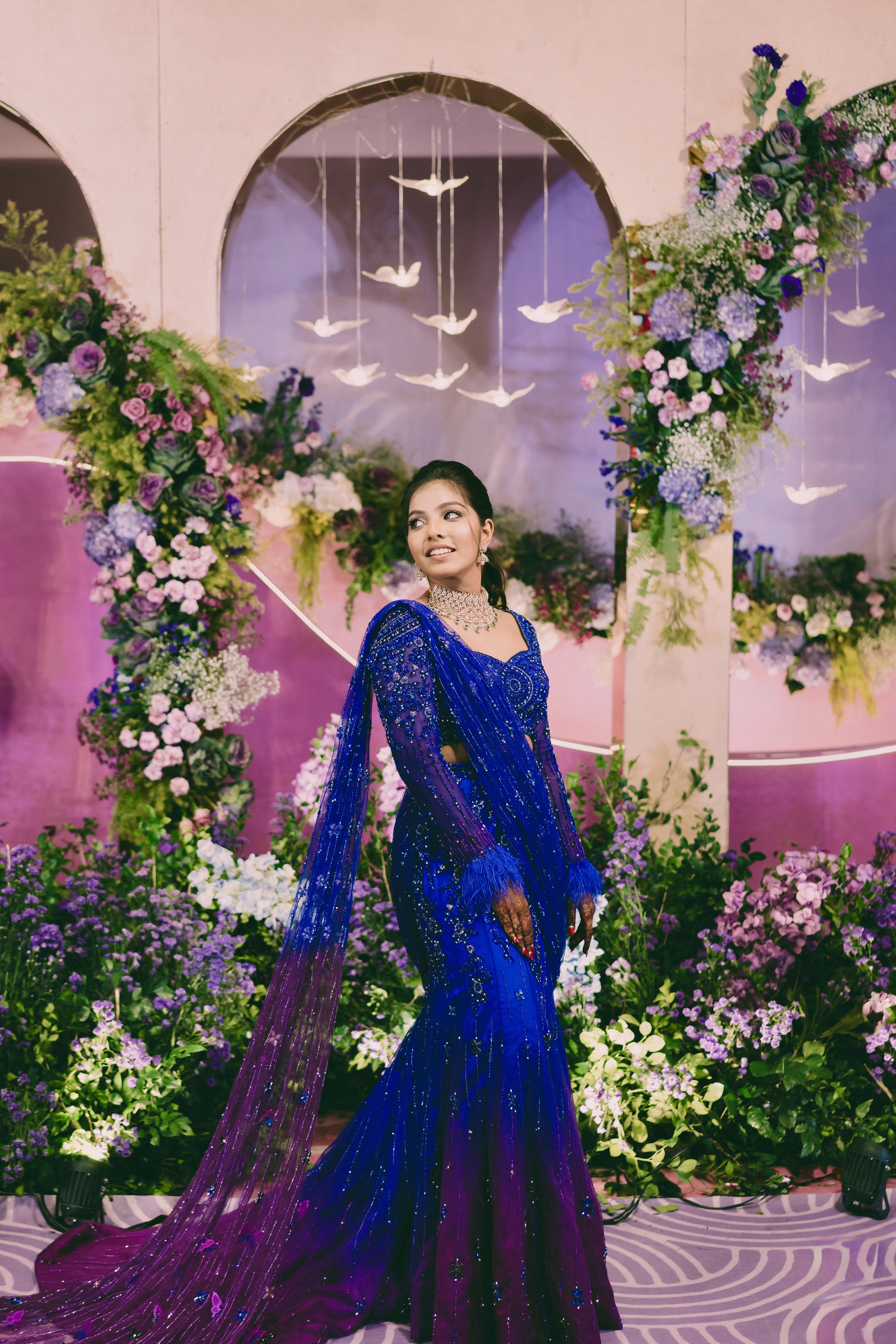 Bride Pooja in a blue and purple mermaid draped lehenga by team Archana Karthick.