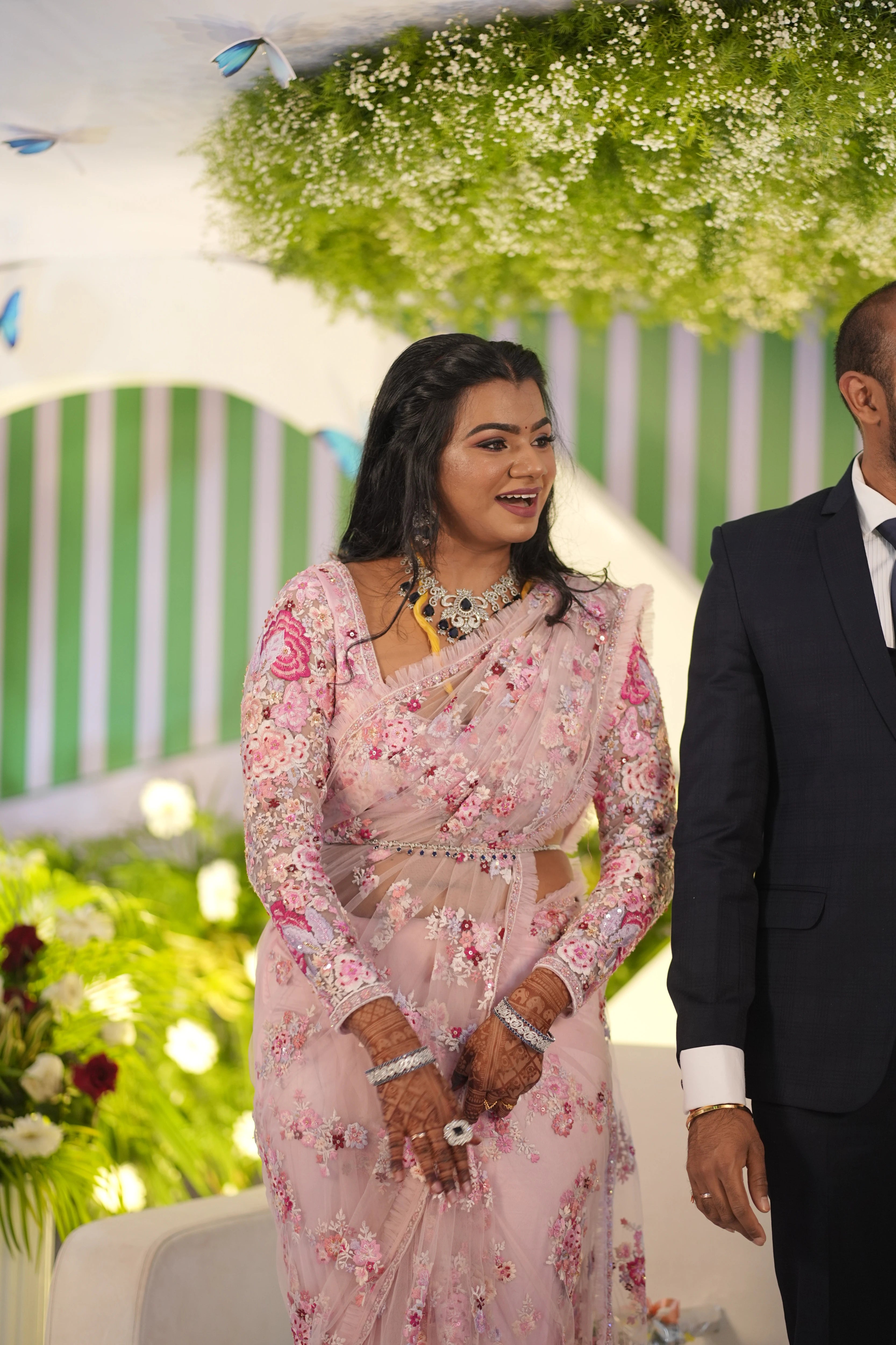 Bride Preethi from Canada smiling in a pink tulle saree, handcrafted by team Archana Karthick.