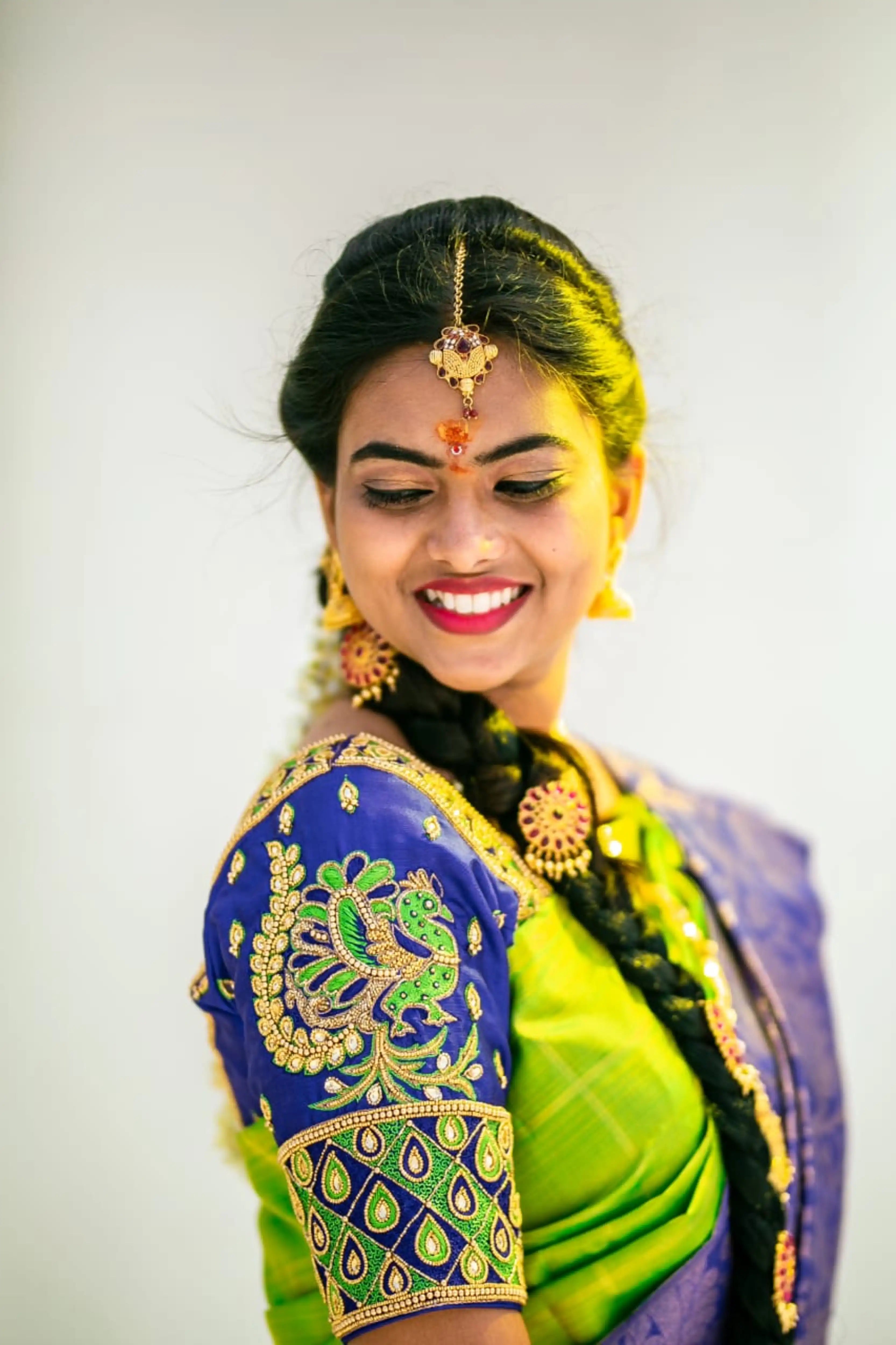 Bride Priya Sathiyan in a blue silk blouse, intricately handcrafted with zardozi, resham, knotwork, kundan and beads by team Archana Karthick.