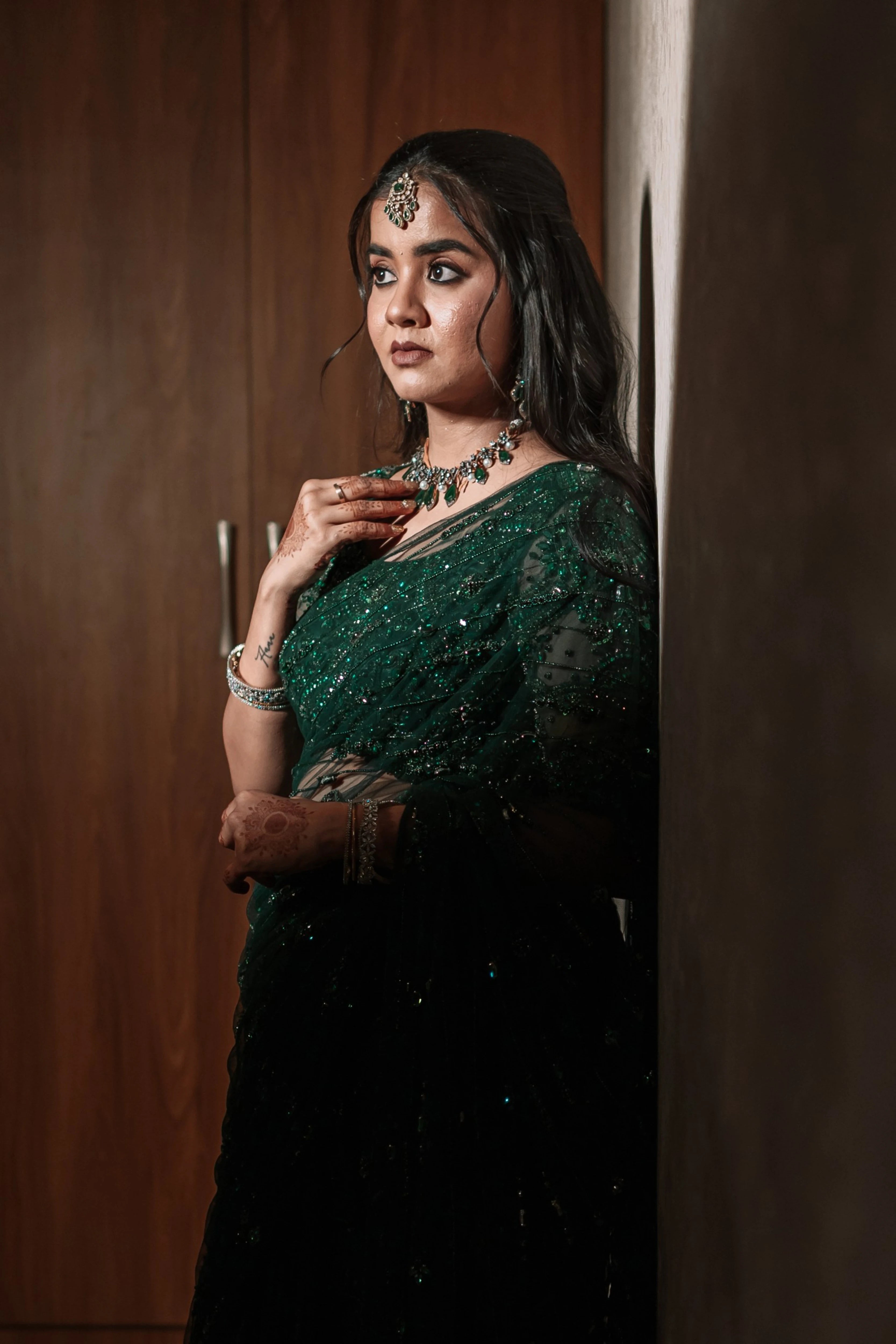 Bride Priyanka posing during photoshoot in a bottle green tulle saree, intricately handcrafted with rhinestones, zardozi, sequins, crystals, cutdana and stones by team Archana Karthick.