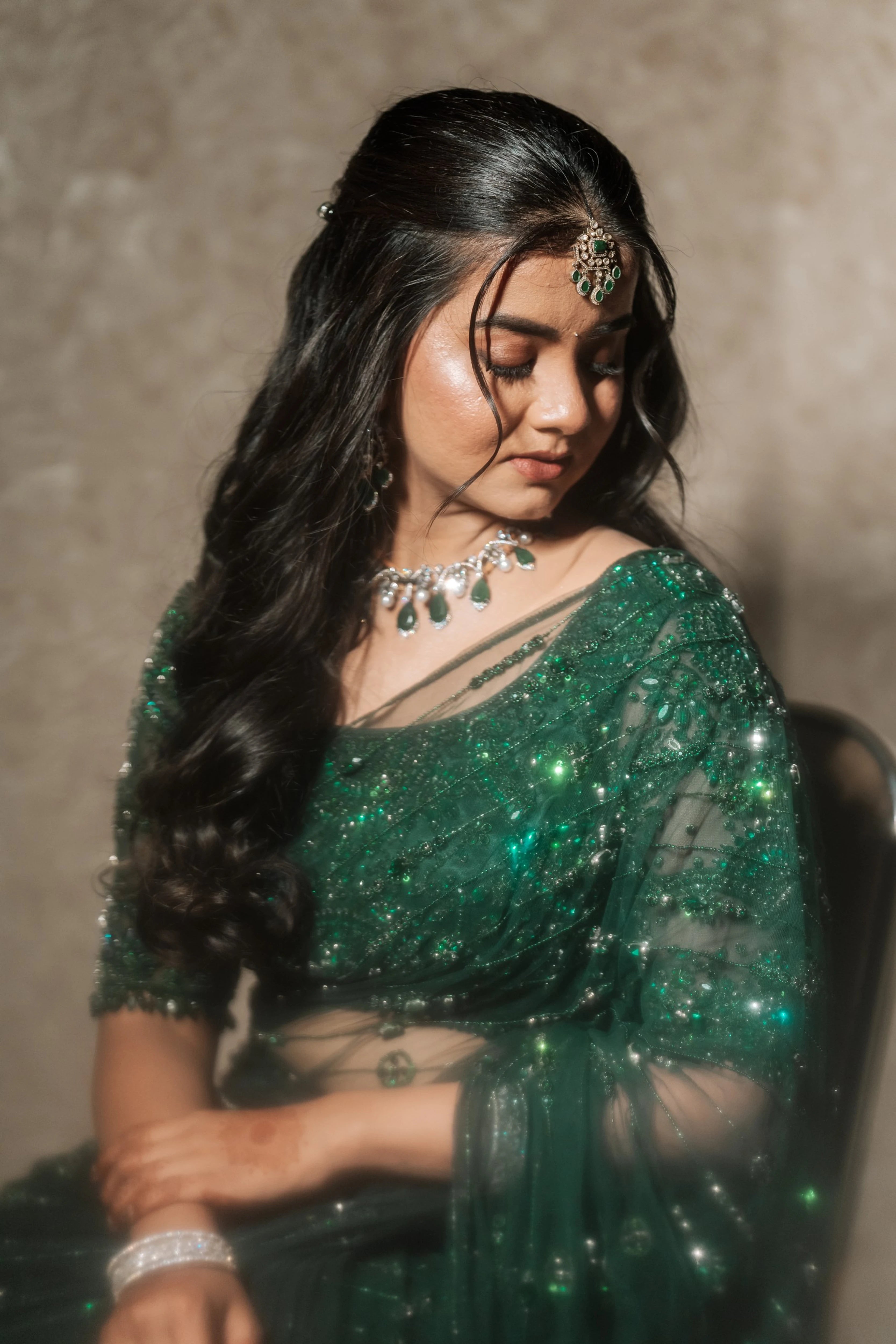 Bride Priyanka posing in a bottle green tulle saree, intricately handcrafted with rhinestones, zardozi, sequins, crystals, cutdana and stones by team Archana Karthick.