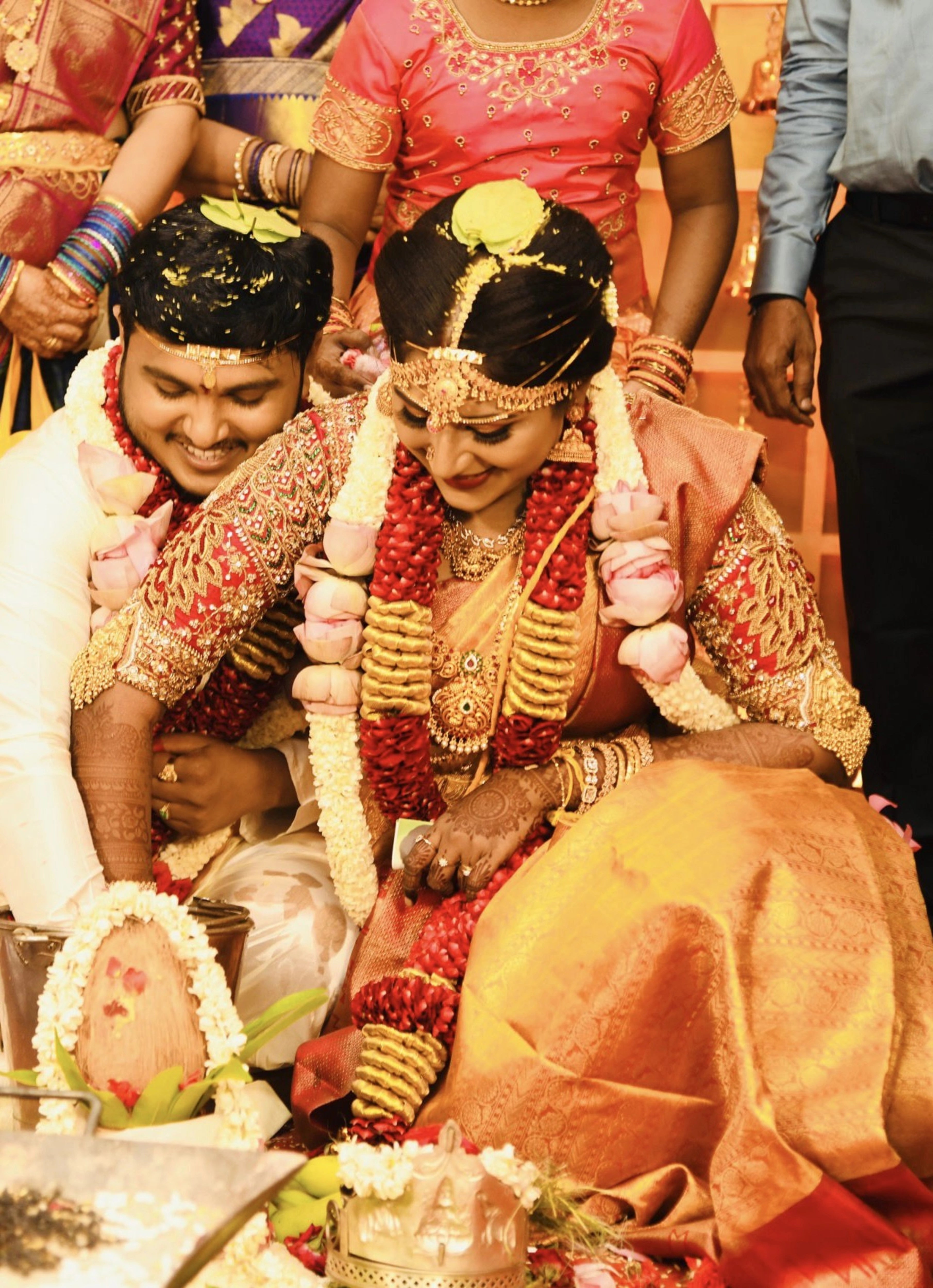 Bride Raji from Ireland laughing in a red silk blouse, handcrafted with stones, zardozi, beads, sequins and kemp stones and goddess pendant by team Archana Karthick.