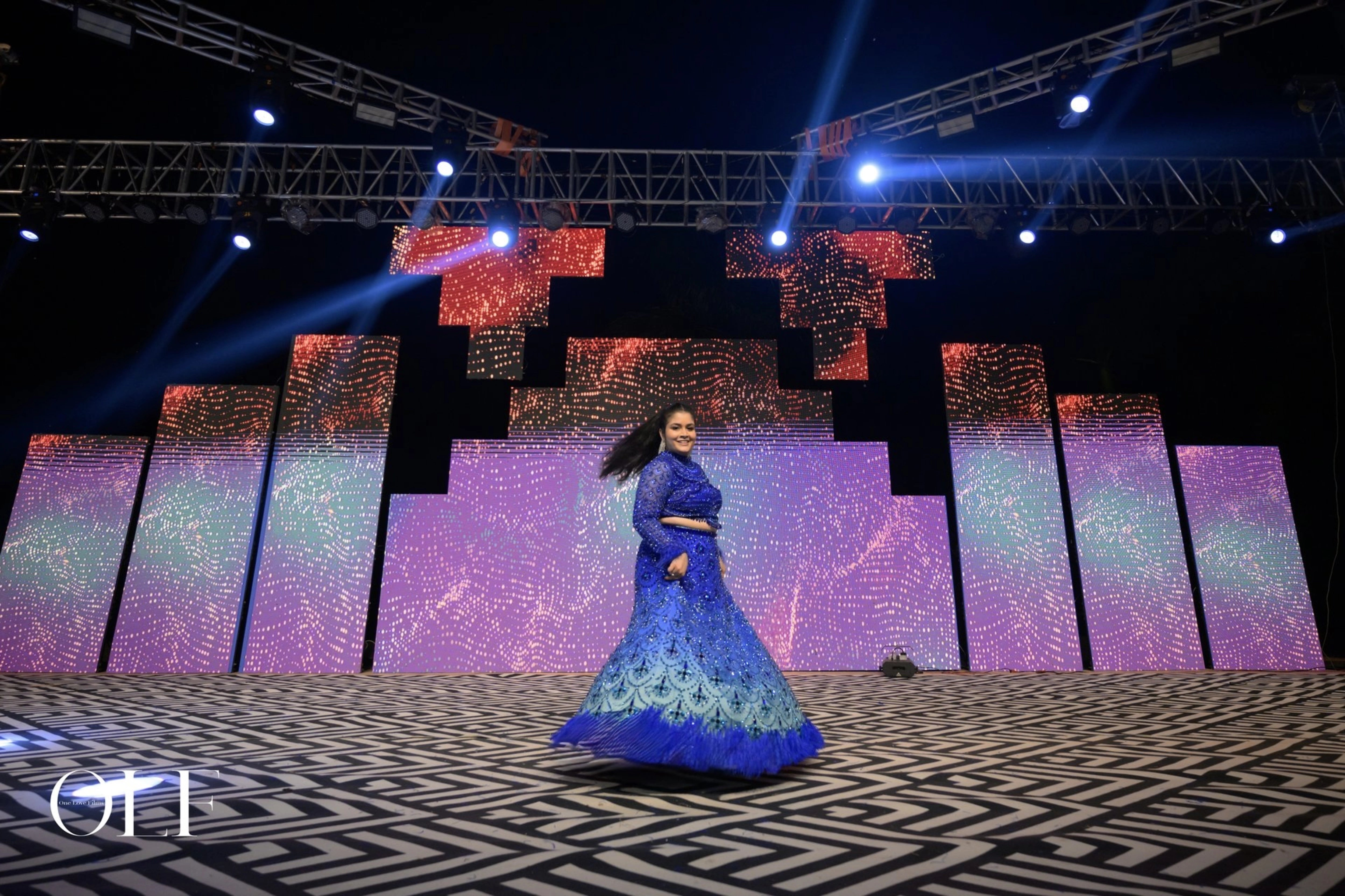 Bride Rasagnya from US in a peacock themed blue tulle lehenga, handcrafted with rhinestones, crystals, cutdana, sequins and feathers by team Archana Karthick.