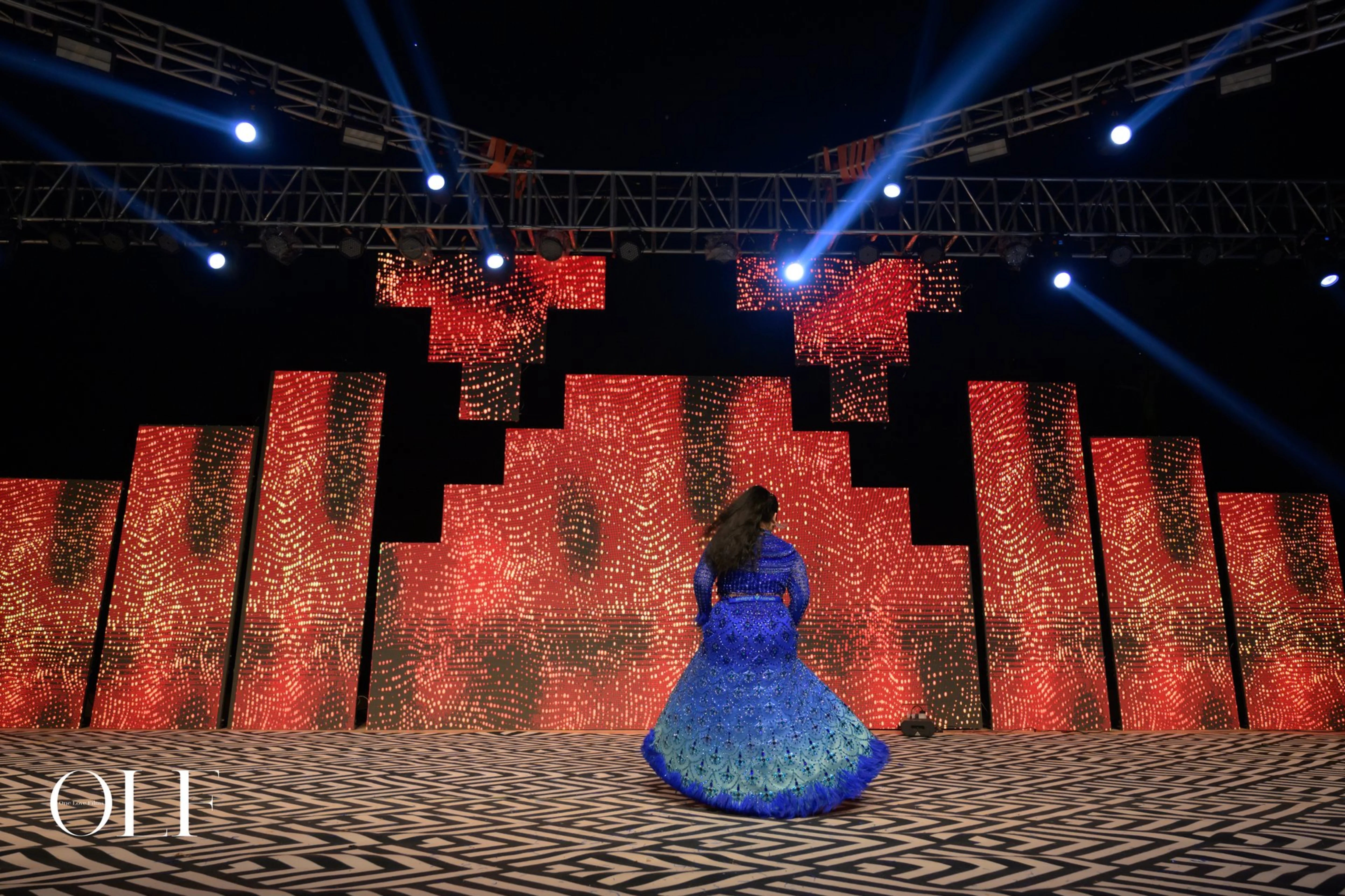 Bride Rasagnya from US on stage in a peacock themed blue tulle lehenga, handcrafted with rhinestones, crystals, cutdana, sequins and feathers by team Archana Karthick.