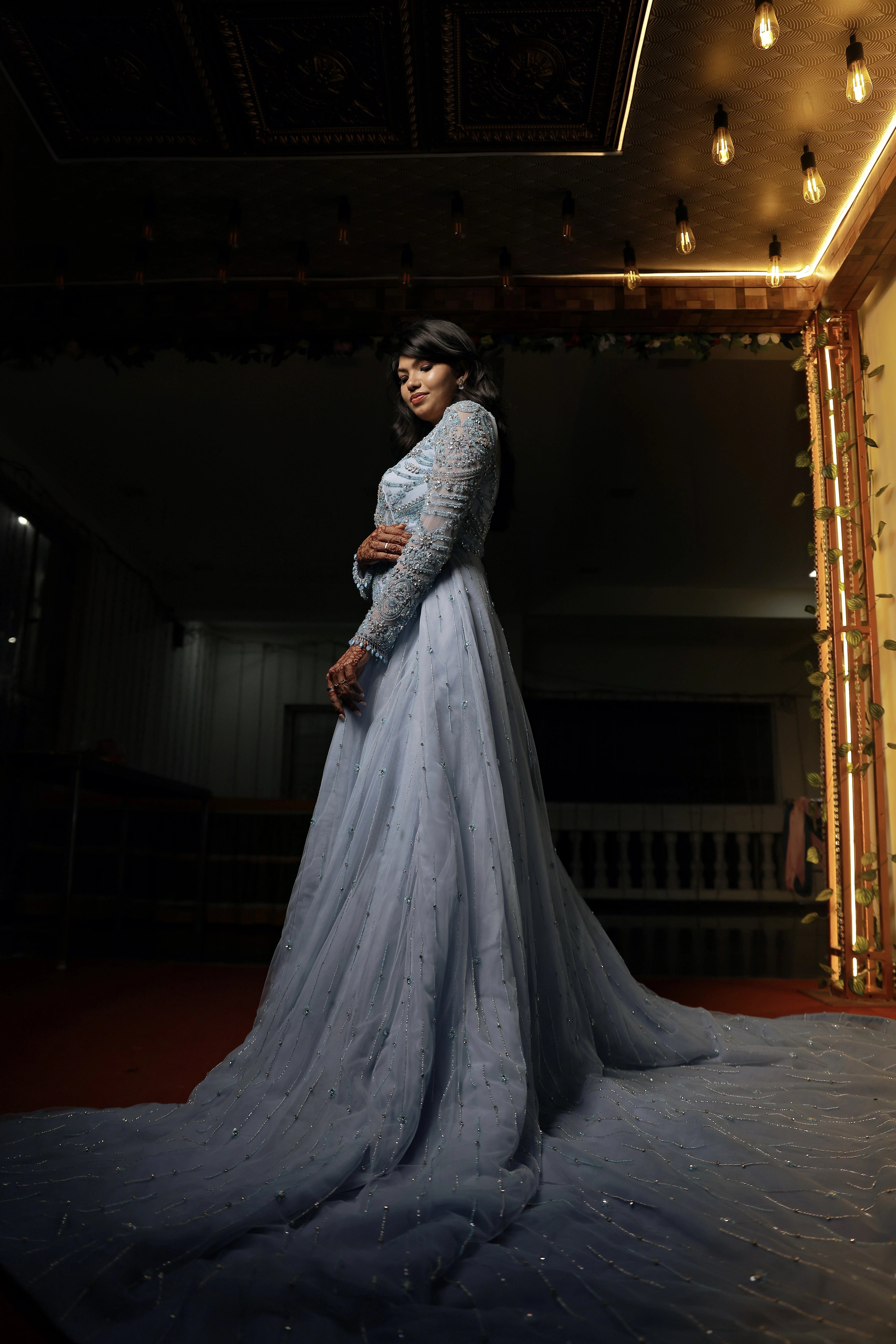 Bride Raxana smiling during photoshoot in a blue tulle mermaid gown by team Archana Karthick.