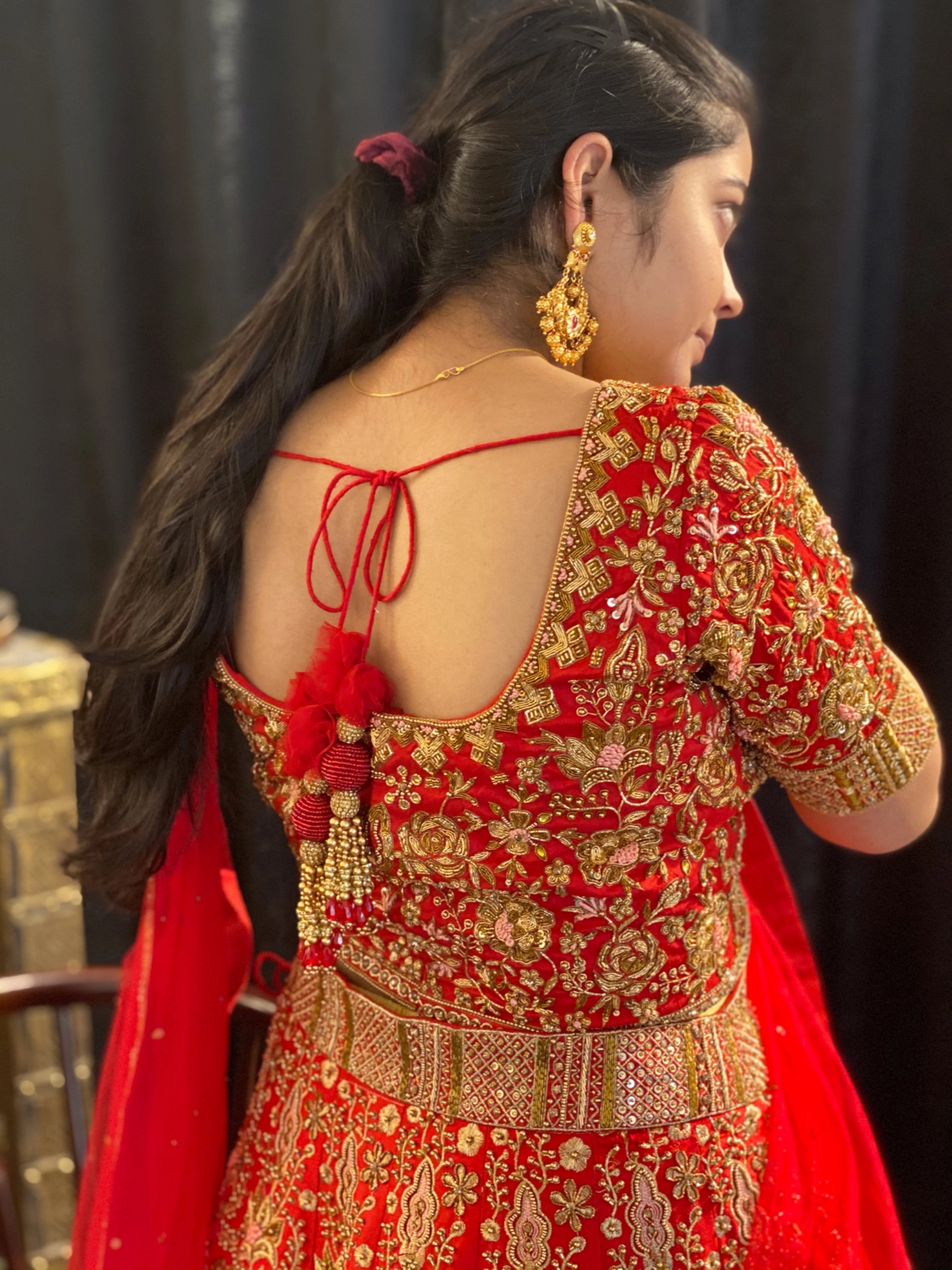 Bride Saba during her fittings in a red raw silk lehenga with a veil and dupatta handcrafted by team Archana Karthick.