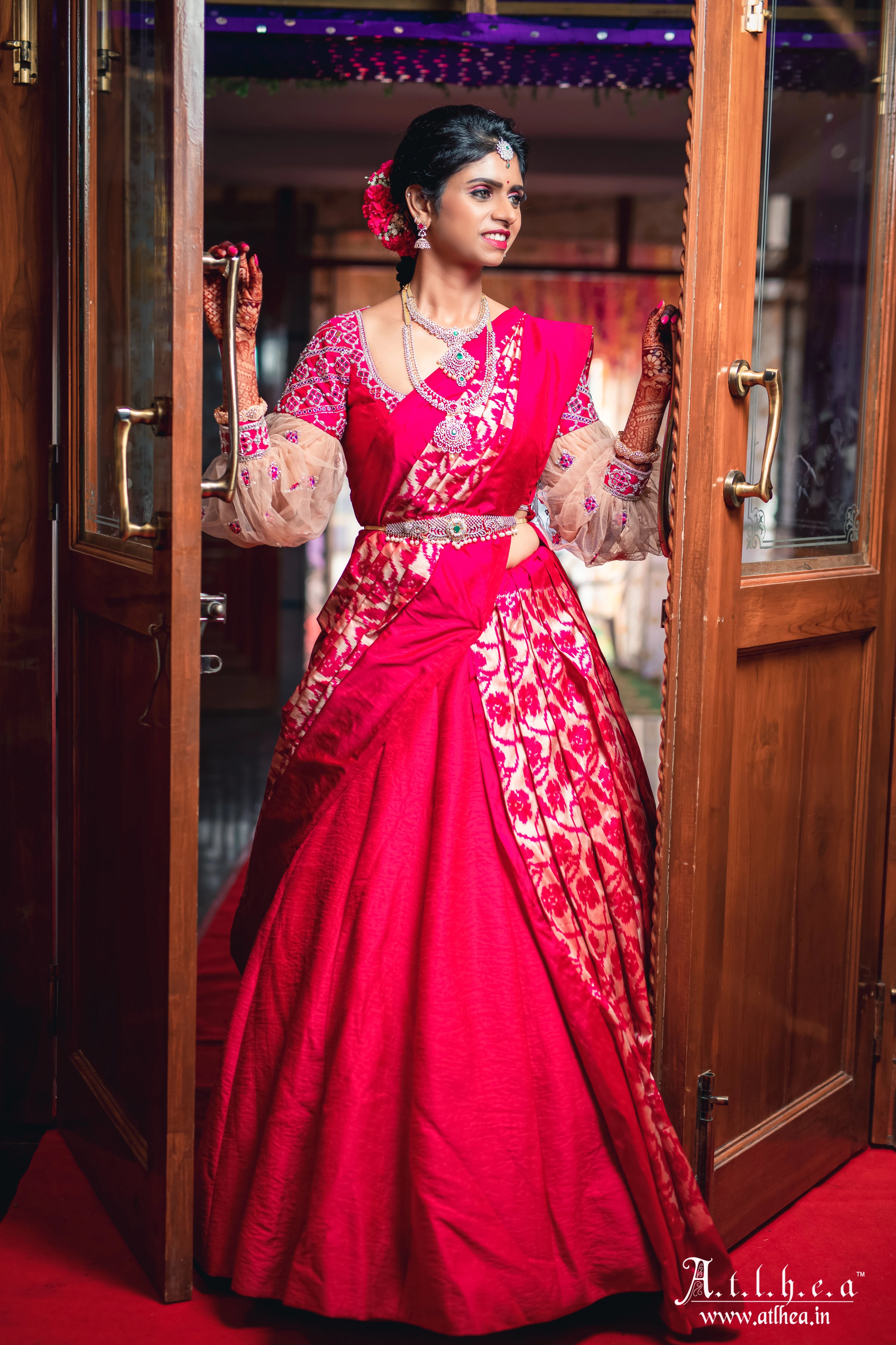 Bride Sahana in a raspberry raw silk half saree, handcrafted intricately with mirror, stones, zardozi and resham by team Archana Karthick.