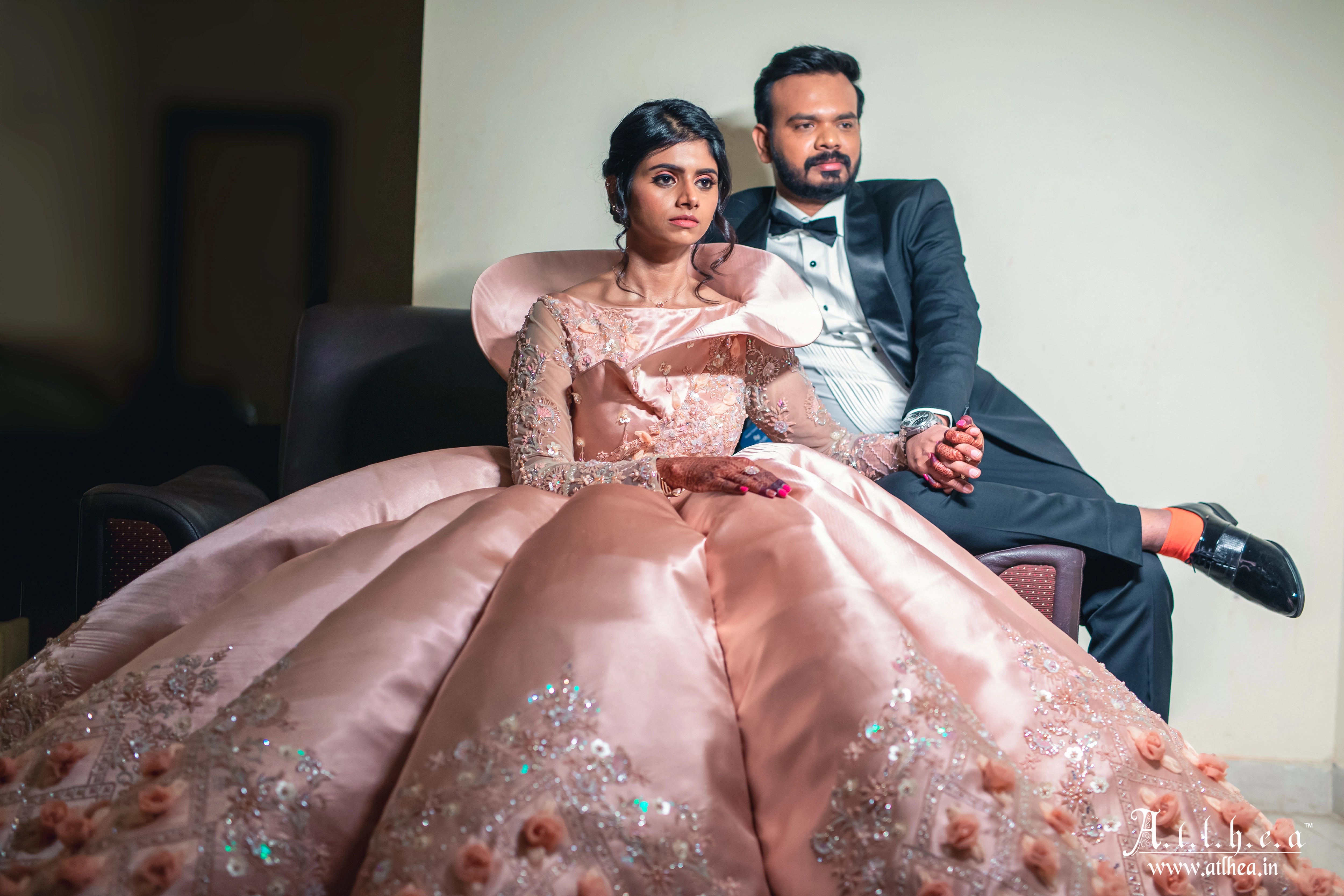 Bride Sahana posing in a peach cream satin structured ball gown, handcrafted intricately with applique, sequins, stones and cutdana by team Archana Karthick.