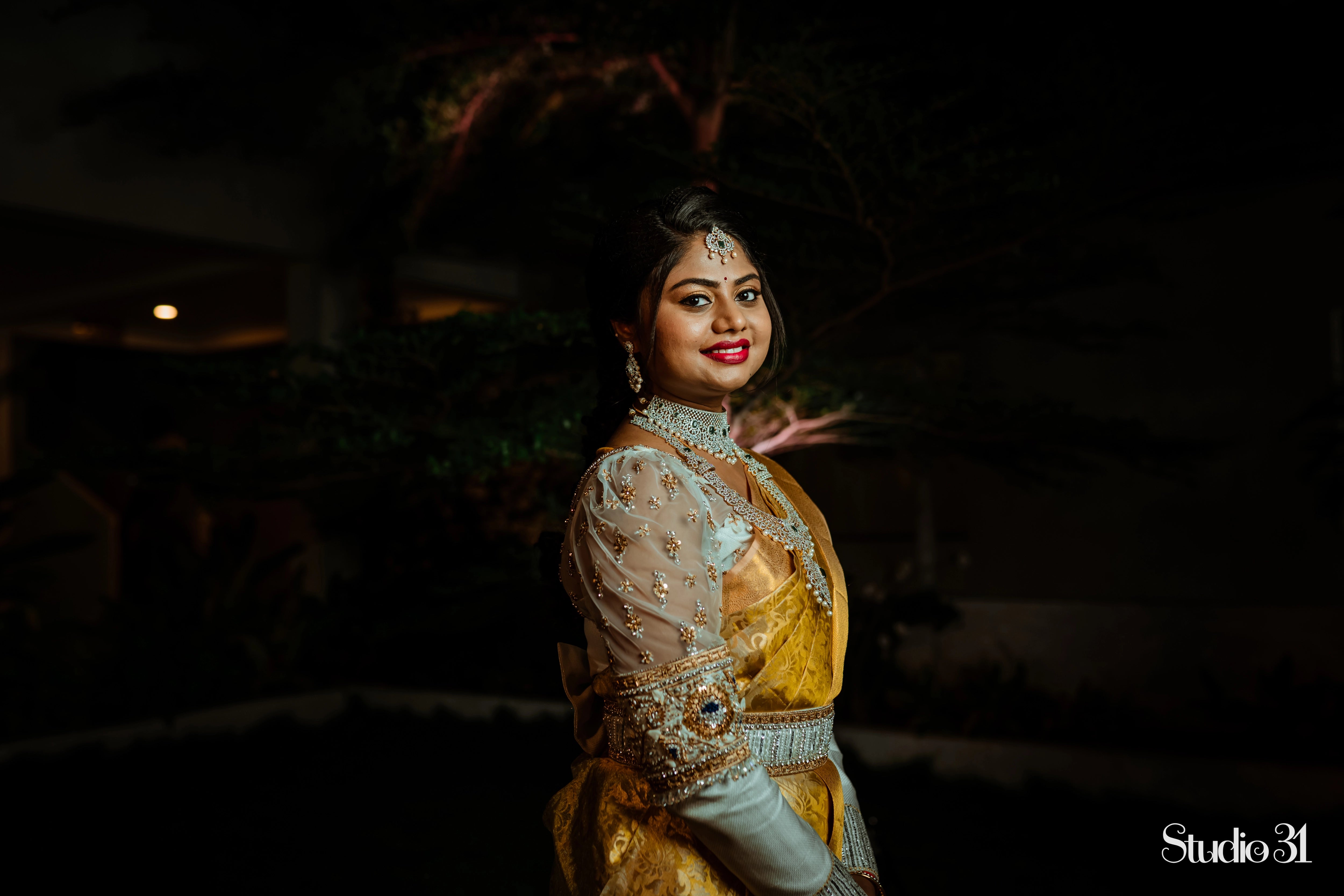 Bride Sailaja from USA smiling in an ivory tulle and silk blouse and belt, intricately handcrafted by team Archana Karthick.