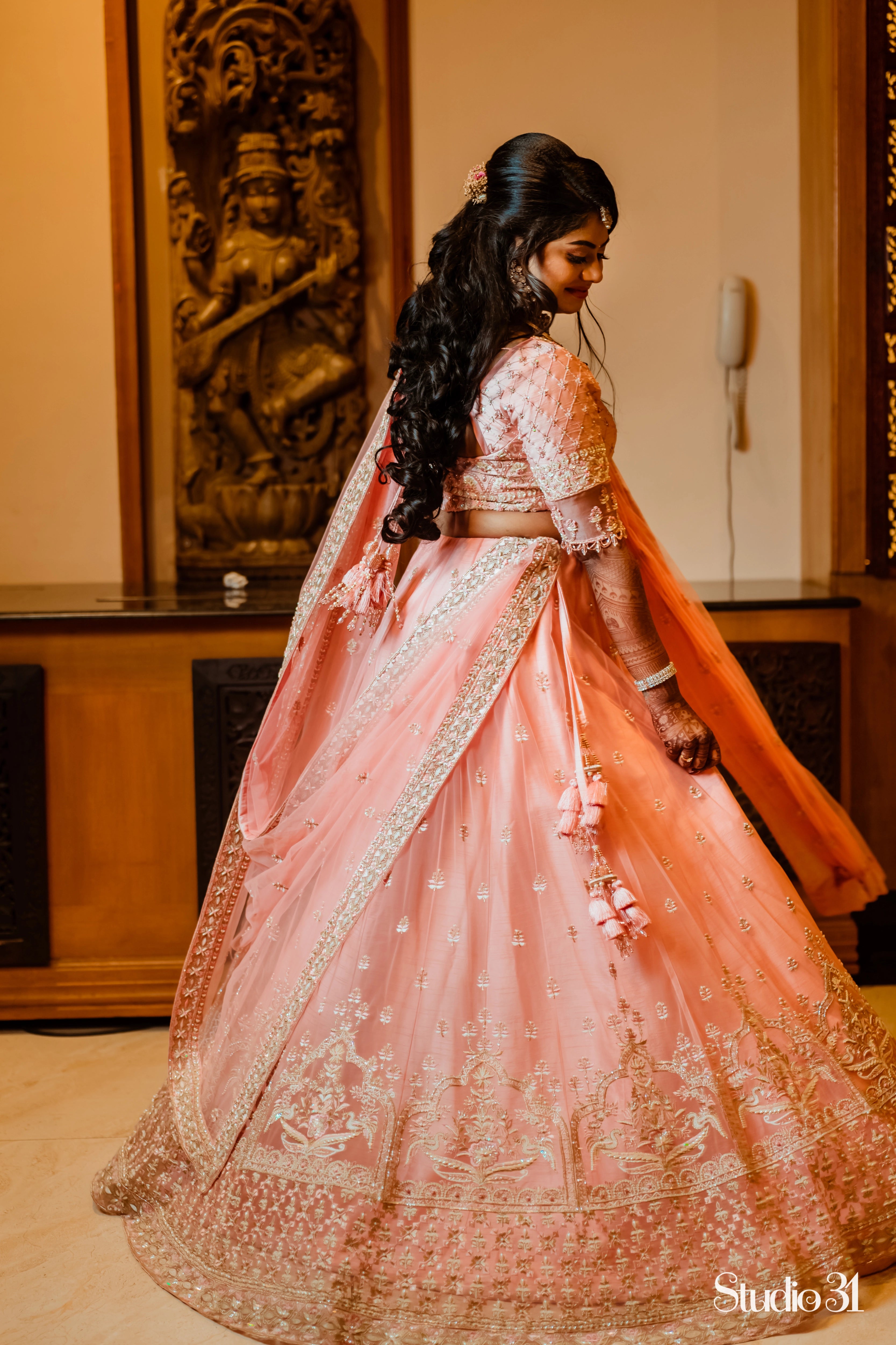 Bride Sailaja from USA twirling in a peach cream raw silk lehenga, intricately handcrafted with pearls, sequins, cutdana, beads, zari and resham by team Archana Karthick.